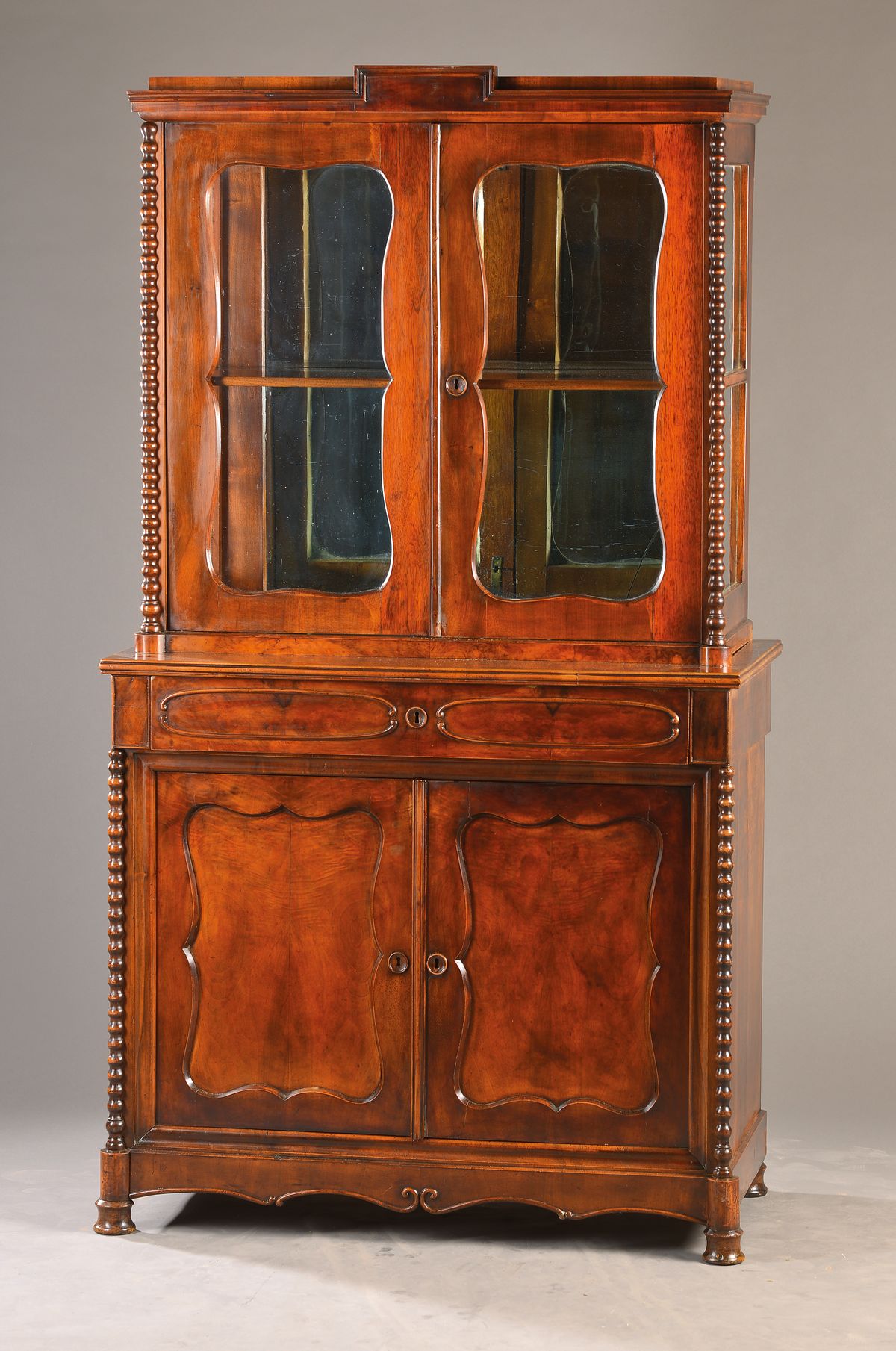 Spätbiedermeierliche Aufsatzvitrine, mitteldeutsch, um 1850/60, Nussbaumfurnier auf Weichholzkorpus, 2-teilig, Unterteil 2-türig u. 1-schübig, ...
