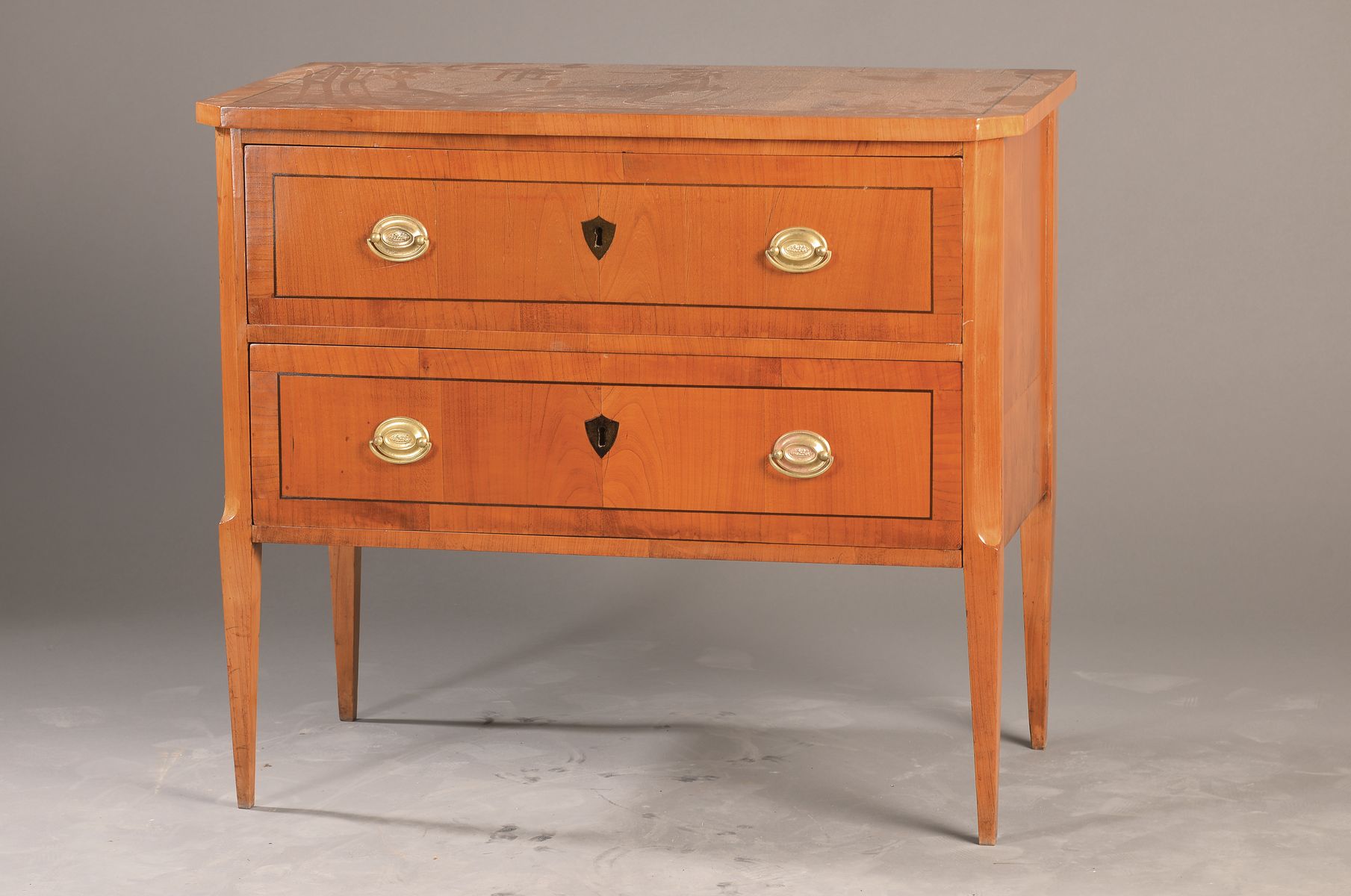 Klassizistische Kommode, süddeutsch, um 1800, Kirschbaumfurnier auf Weichholzkorpus, 2-schübig, orig. Beschläge, wappenförmige ...