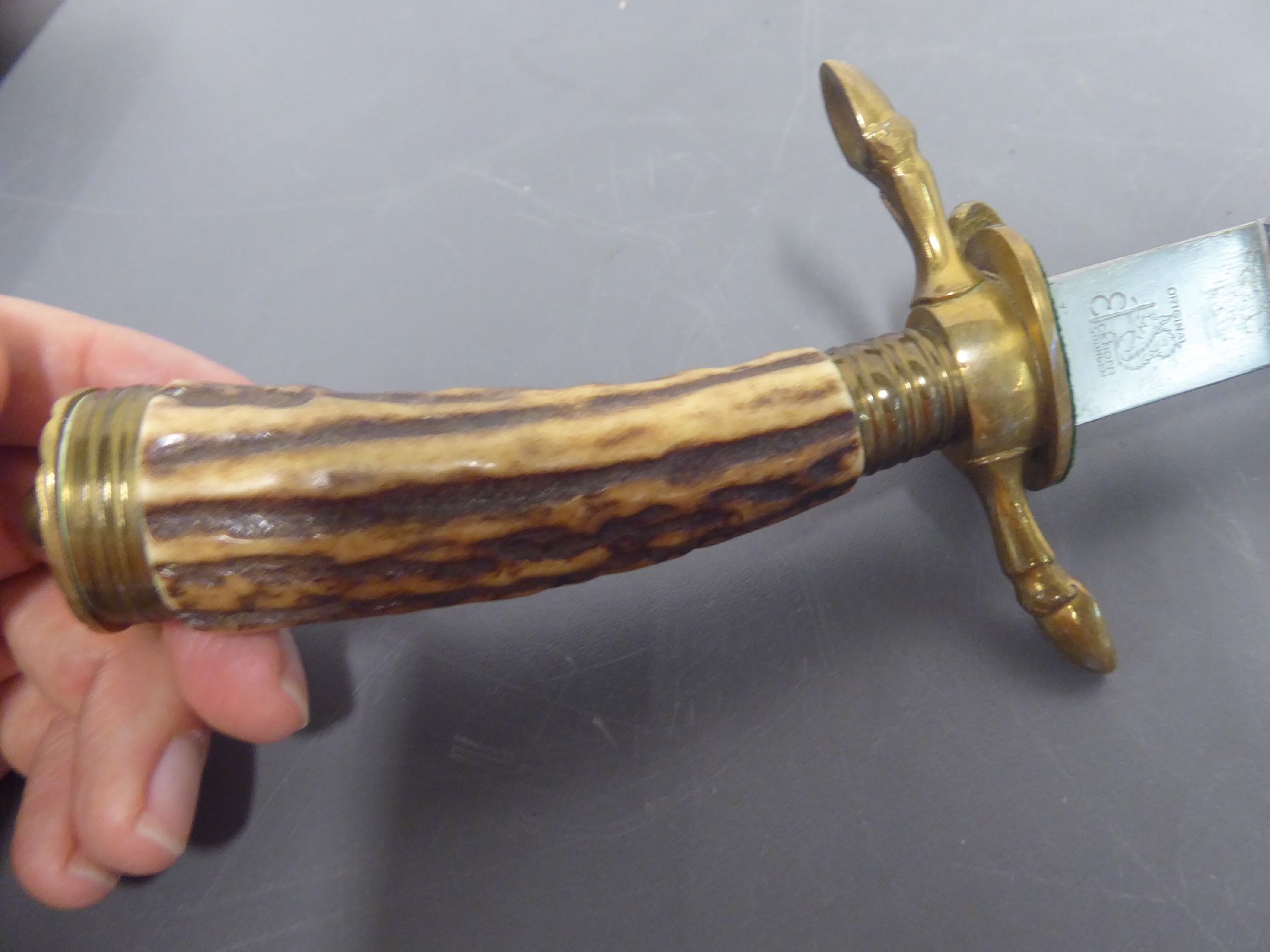 Detail i: Hirschfänger, deutsch, um 1880/90, Hirschhorngriff, Muschelverzierung, Messing, Heft in Form von Klauenfüssen, gravierte Stahlklinge mit ...