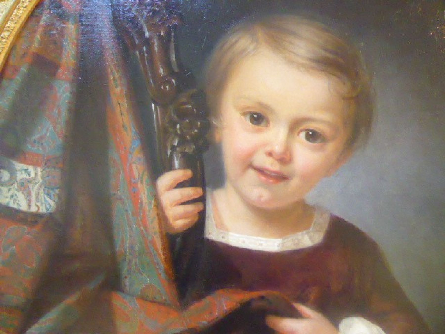 Detail b: Anna Felix, 1827 - 1863, Kinderporträt, kleines Mädchen schaut lächelnd den Betrachter an, neben ihr ein Stuhl mit beschnitzter Lehne, darüber ...