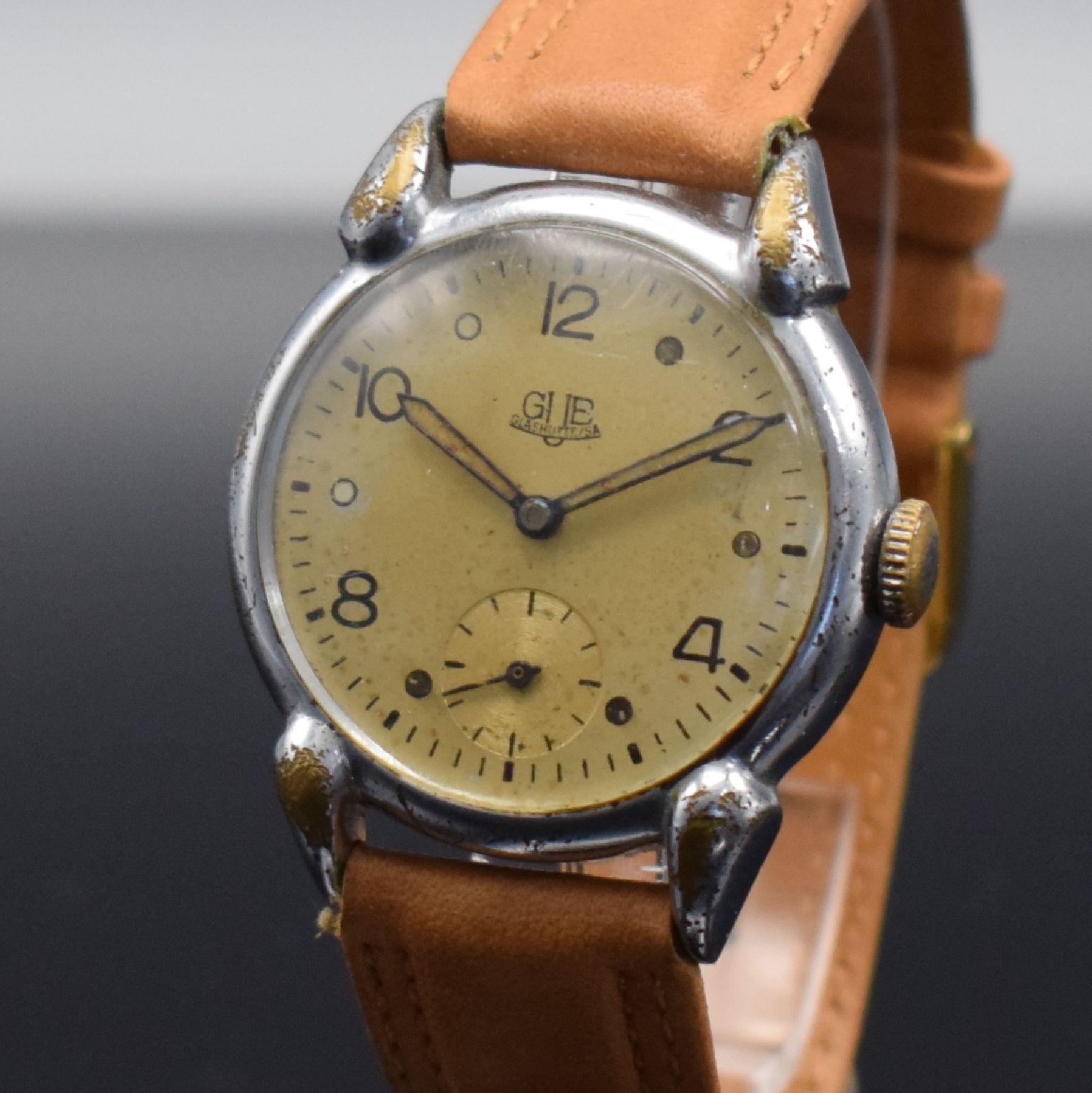 Detail c: GUB Herrenarmbanduhr mit Kaliber 60, Handaufzug, DDR um 1952, verchr. Metallgeh. m. ausgef. Bandanst. ber., Edelstahlboden aufgedr., silb. Zifferbl. ...
