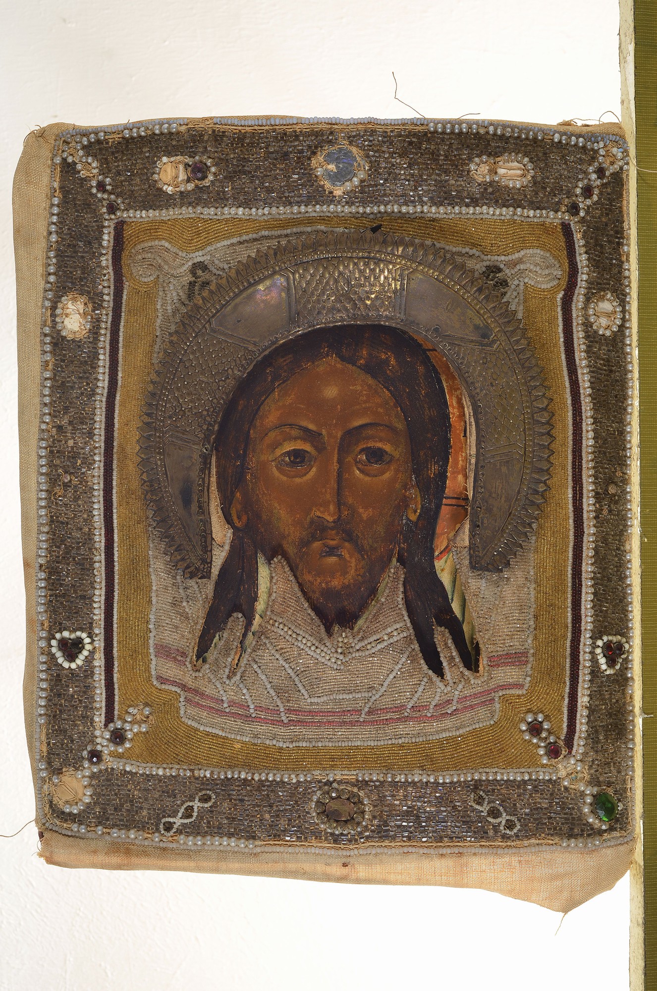 Detail k: Ikone, Ukraine, um 1830-40, Christus Pantokrator, Tempera auf Holz, Oklad Stoff reich mit Glasperlchen bestickt, lose, ca. 31x27cm, Altersspuren