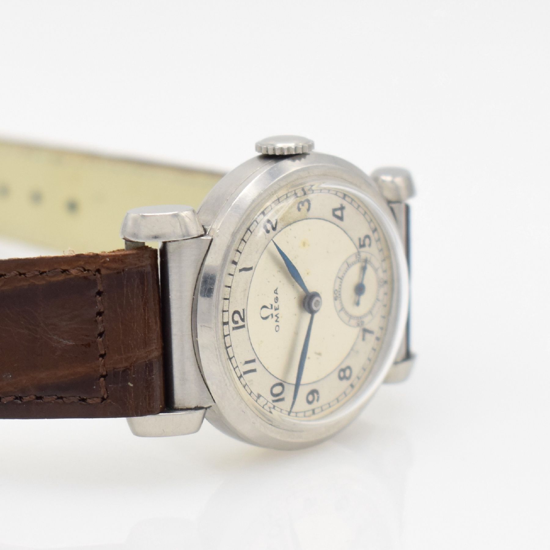 Detail e: OMEGA Armbanduhr mit ausgefallenen Bandanstößen in Stahl, Schweiz um 1940, Handaufzug, unpoliertes Geh., Boden & Glasrand aufgedr., silb. ...