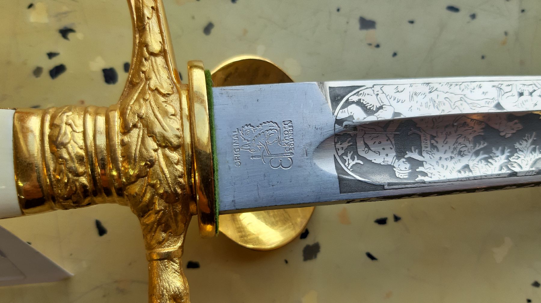 Detail e: Kurzer Hirschfänger, um 1920/30, geätzte Klinge mit Hohlkehle; Jagdmotive beidseitig, "Original Eickhorn Solingen", vergoldeter ...