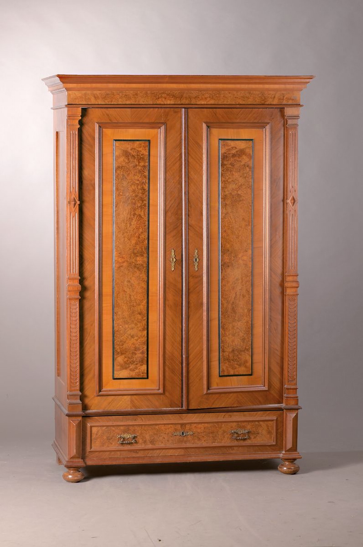 Kleiderschrank, Gründerzeit, um 1890, Nußbaumfurnier, z.T. Wurzelnuß, kassettiert, Sockelschublade, Tür verzogen, poliert, Alters- und ...