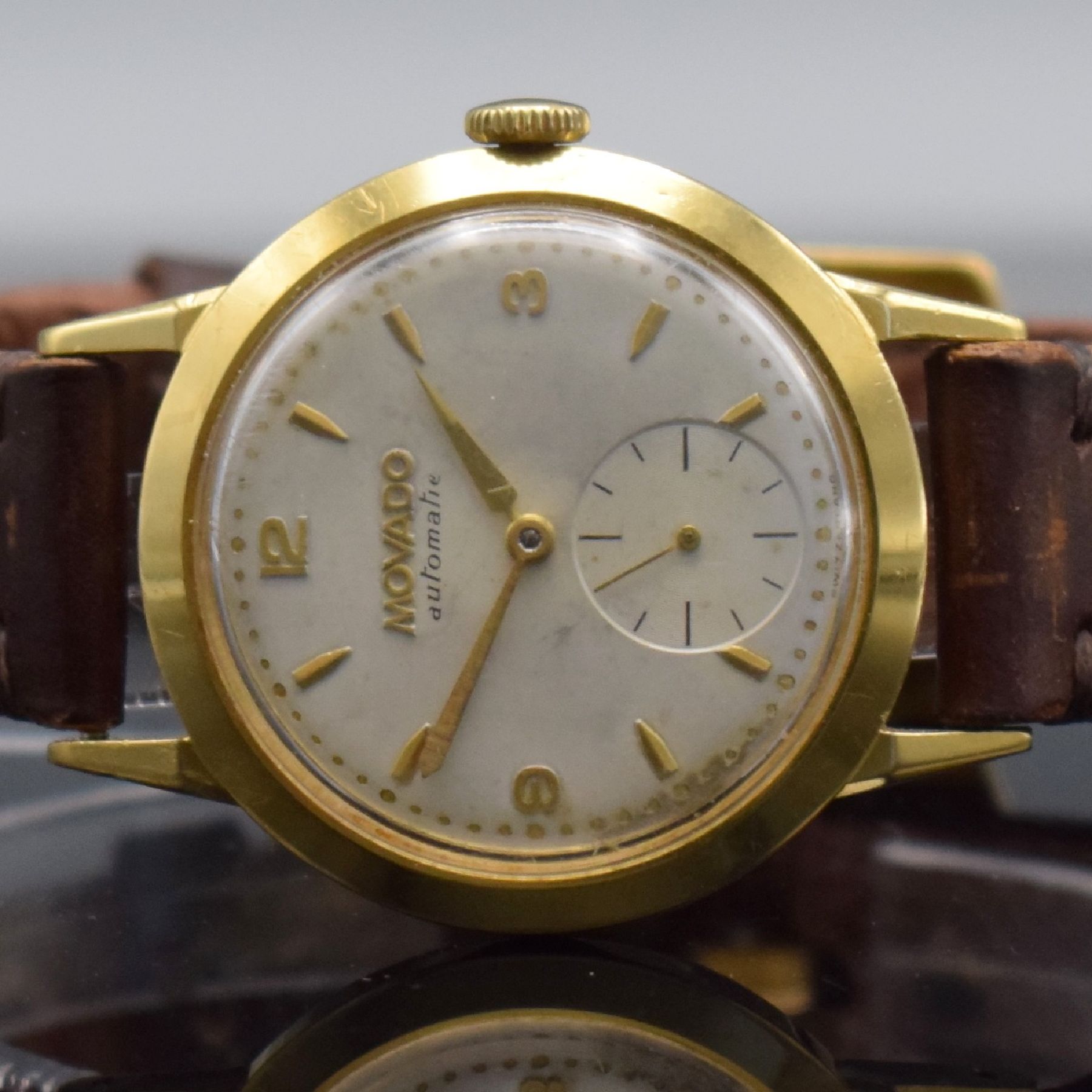 Detail a: MOVADO Herrenarmbanduhr in GG 750/000 mit Hammerautomatik, Schweiz um 1950, Boden & Metallcuvette aufgedr., silb. Zifferbl. m. arab. Zahlen & gold. ...