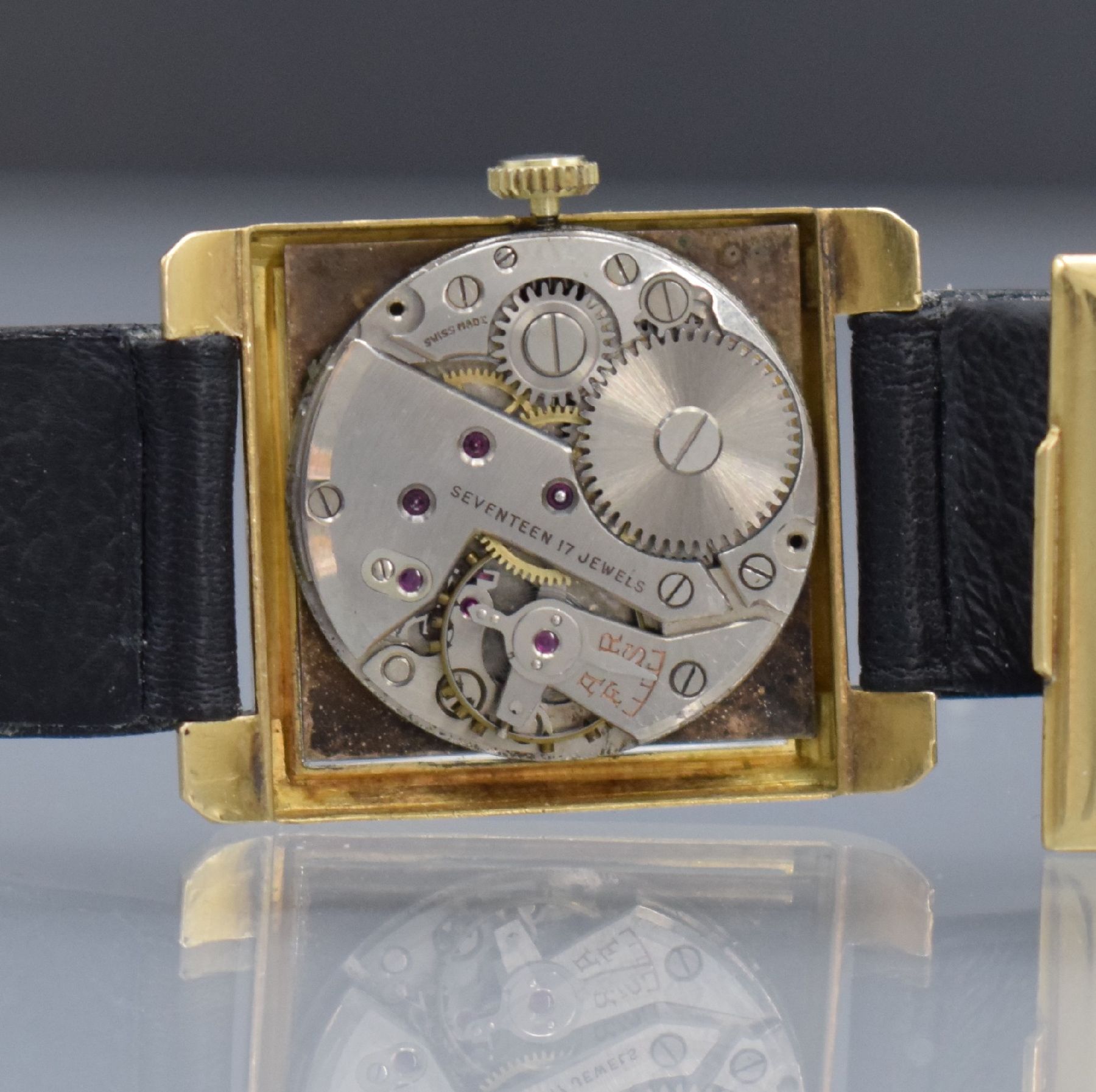 Detail e: Rechteckige Armbanduhr in GG 750/000, Schweiz um 1940, Handaufzug, Boden aufgedr., silb. Zifferblatt mit Fehldruck, gold. arab. Zahlen, Ind. & ...