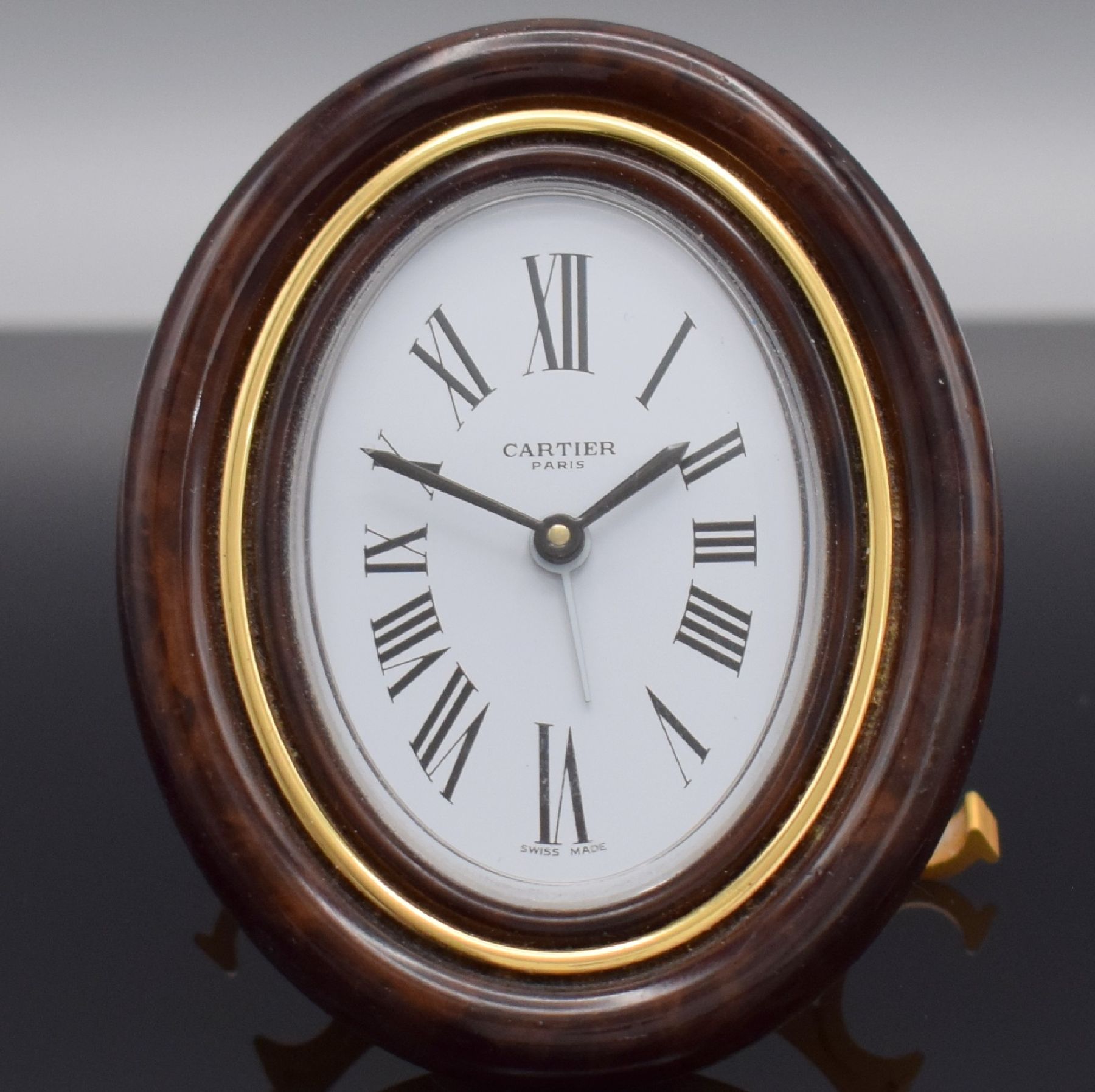 Detail a: CARTIER Paris Tischwecker, Schweiz 1980er Jahre, quarz, Ref. 7519, verg. Messinggeh. z. T. in Holzoptik braun lackiert, emailfarb. Zifferbl. m. röm. ...