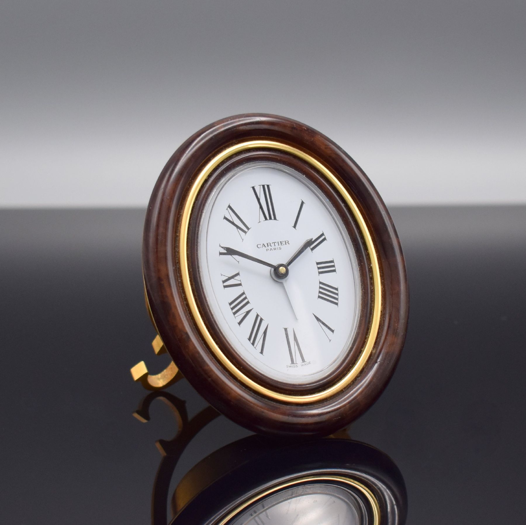 Detail b: CARTIER Paris Tischwecker, Schweiz 1980er Jahre, quarz, Ref. 7519, verg. Messinggeh. z. T. in Holzoptik braun lackiert, emailfarb. Zifferbl. m. röm. ...