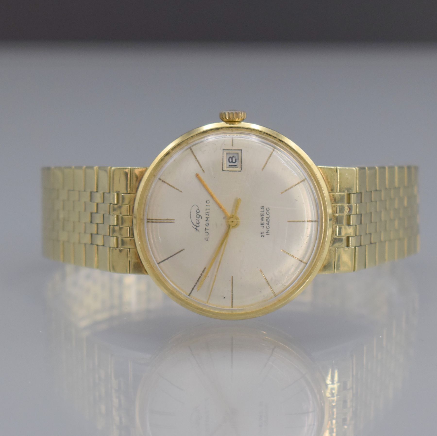 HAGO Herrenarmbanduhr in GG 585/000, Deutschland/Schweiz um 1960, Automatik, aufgedr. Boden dell., anges. Goldband, silb. Zifferbl., gold. Zeiger, ...