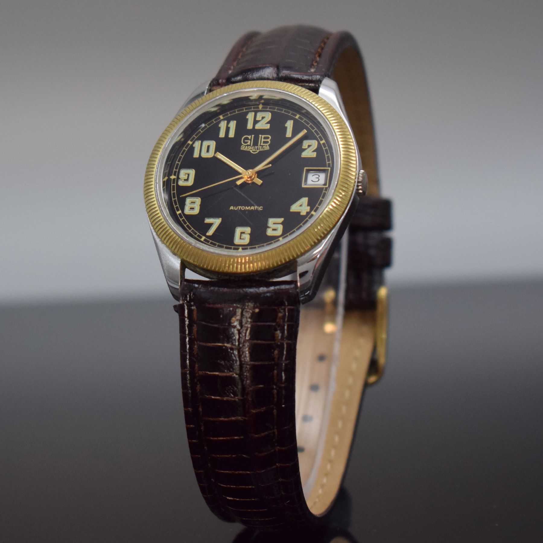 Detail b: GUB Herrenarmbanduhr, Deutschland/Schweiz um 1993, Automatik, verchr. Metallgeh. beids. vergl., Verchromung teilw. besch., geriffelte Lünette verg., ...