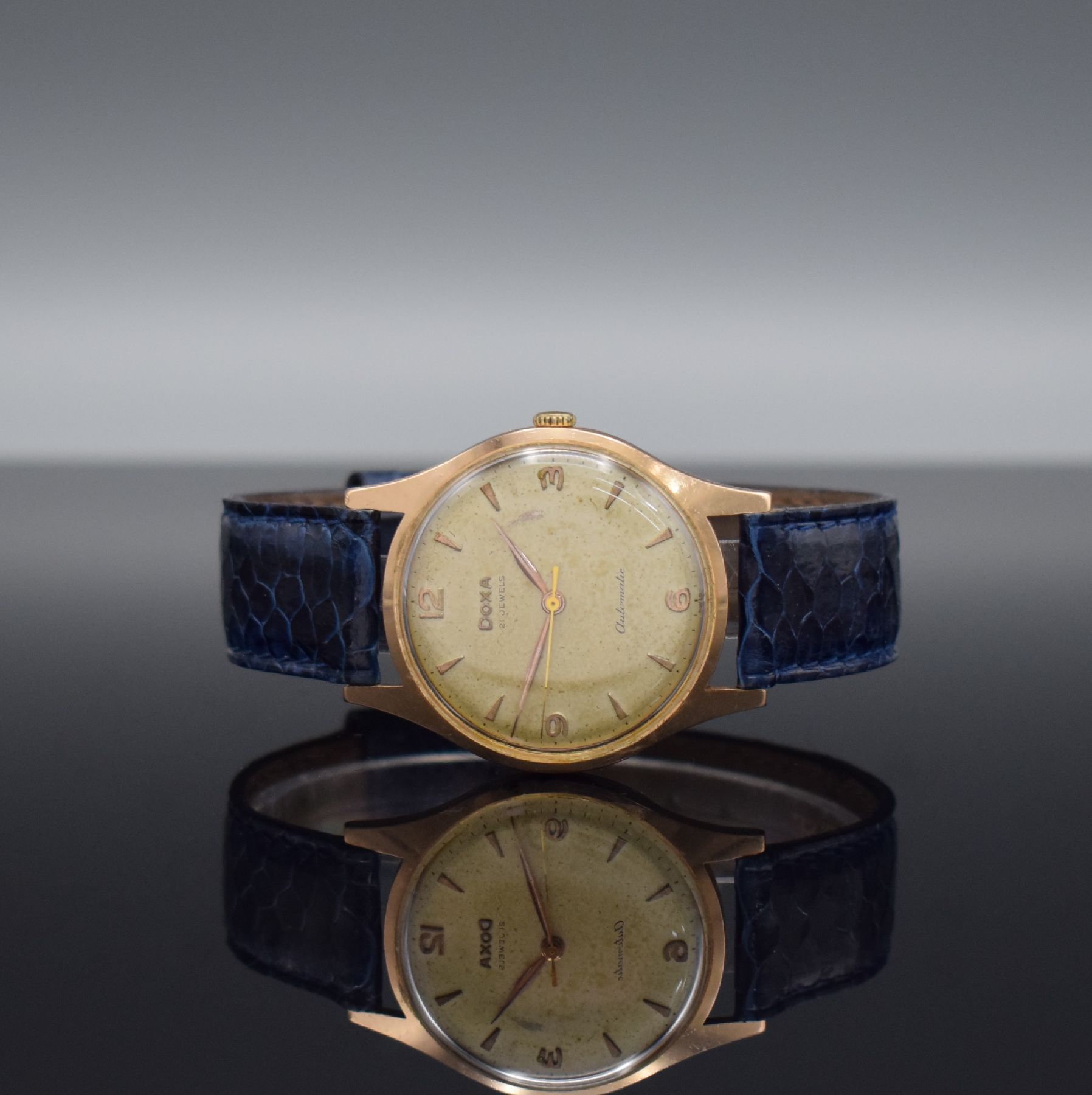 DOXA Herrenarmbanduhr in RoseG 585/000, Schweiz um 1955, Automatik, 2-teil. Gehäuse dell., Boden aufgedr., patiniertes Zifferbl. m. gold. Std.-Ind., ...