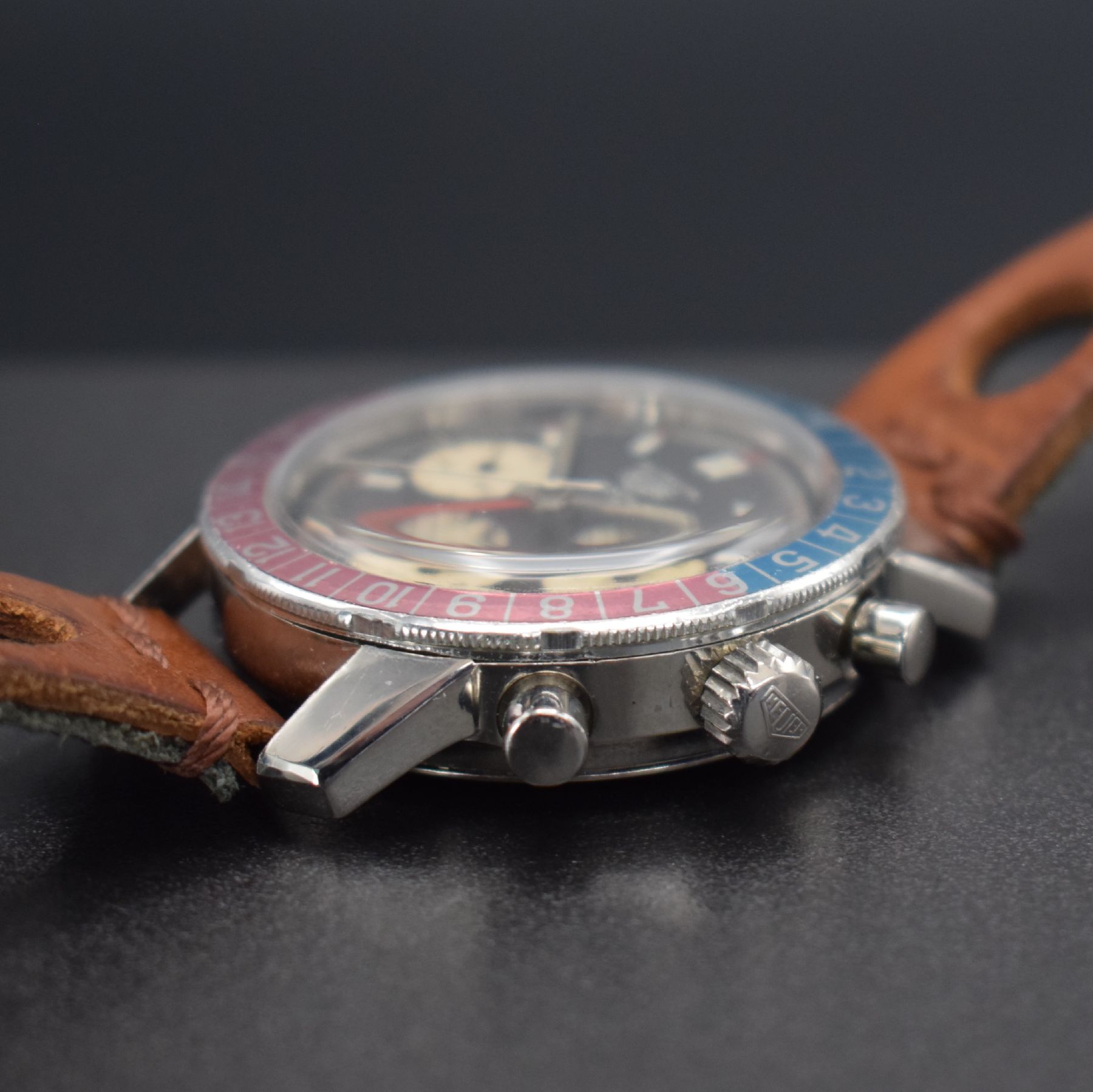 Detail d: HEUER seltener Schaltradchronograph Autavia GMT Referenz 2446, Handaufzug, Schweiz um 1969, gedr. Edelstahlgeh. orig. Krone & Drücker, rot/blaue ...