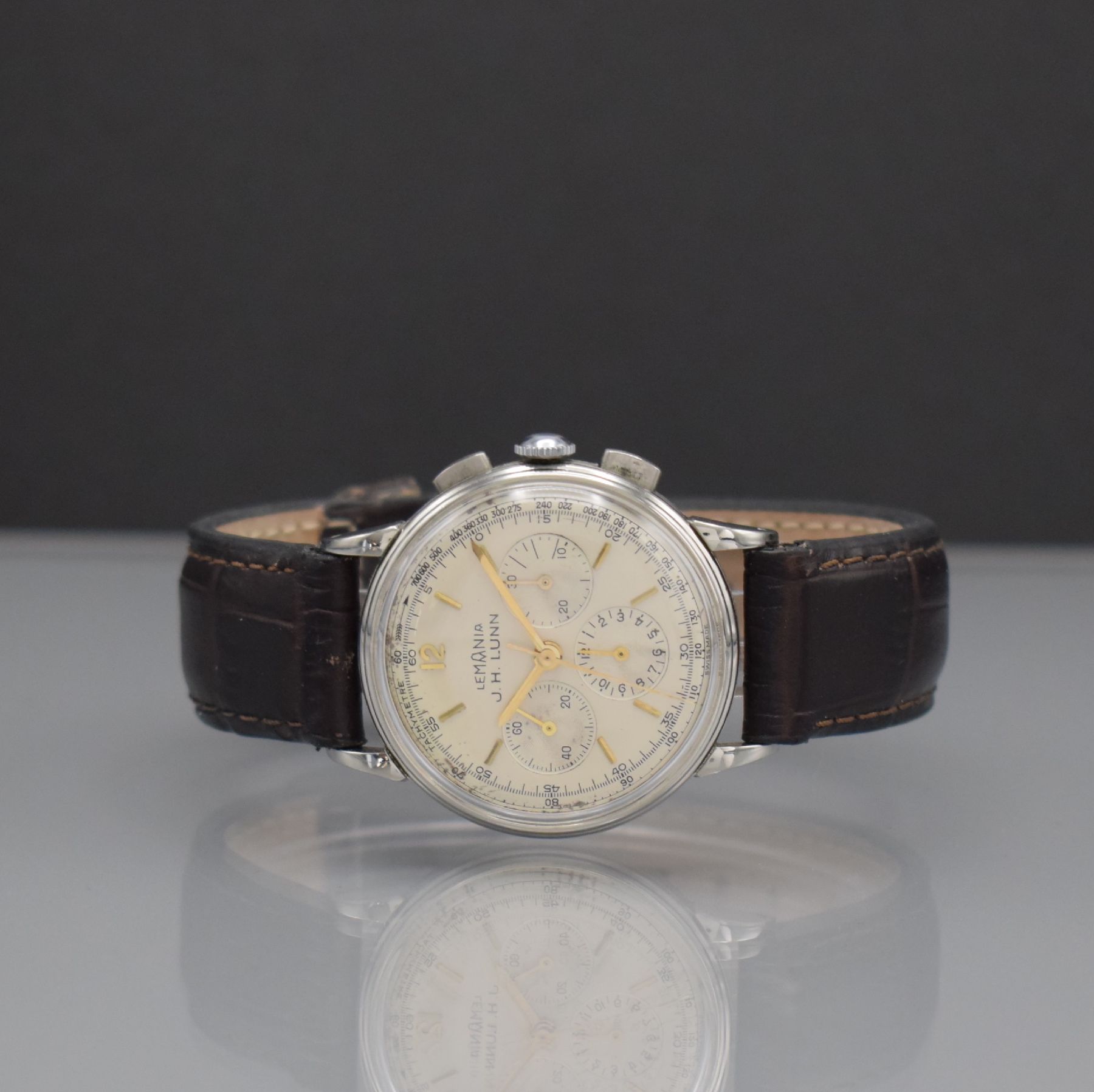 LEMANIA Armbandchronograph in Stahl, Handaufzug, Schweiz um 1960, 3-teil. Edelstahlgeh., Boden & Glasrand aufgedr., silb. Zifferbl. m. gold. aufges. ...