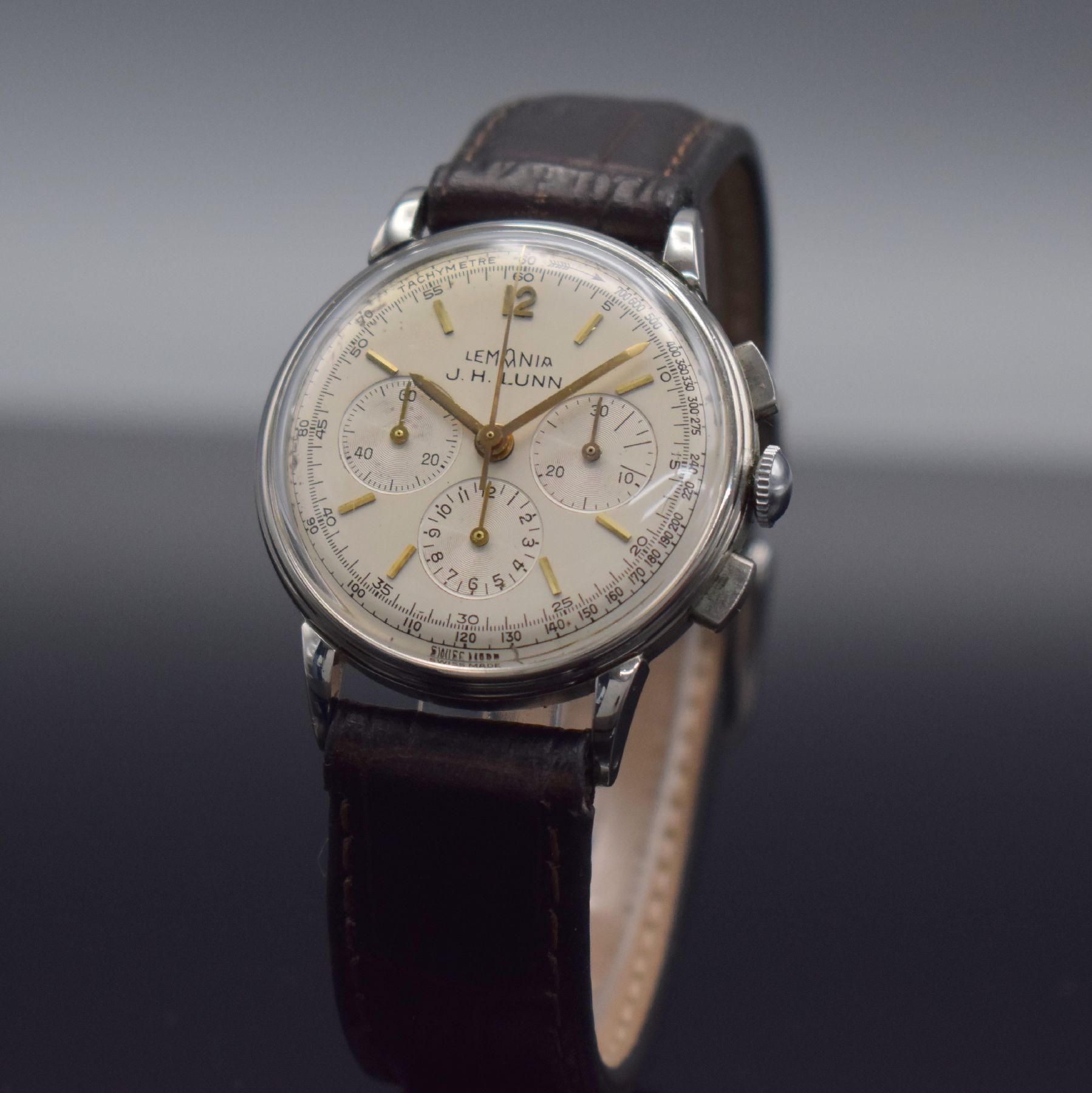 Detail b: LEMANIA Armbandchronograph in Stahl, Handaufzug, Schweiz um 1960, 3-teil. Edelstahlgeh., Boden & Glasrand aufgedr., silb. Zifferbl. m. gold. aufges. ...