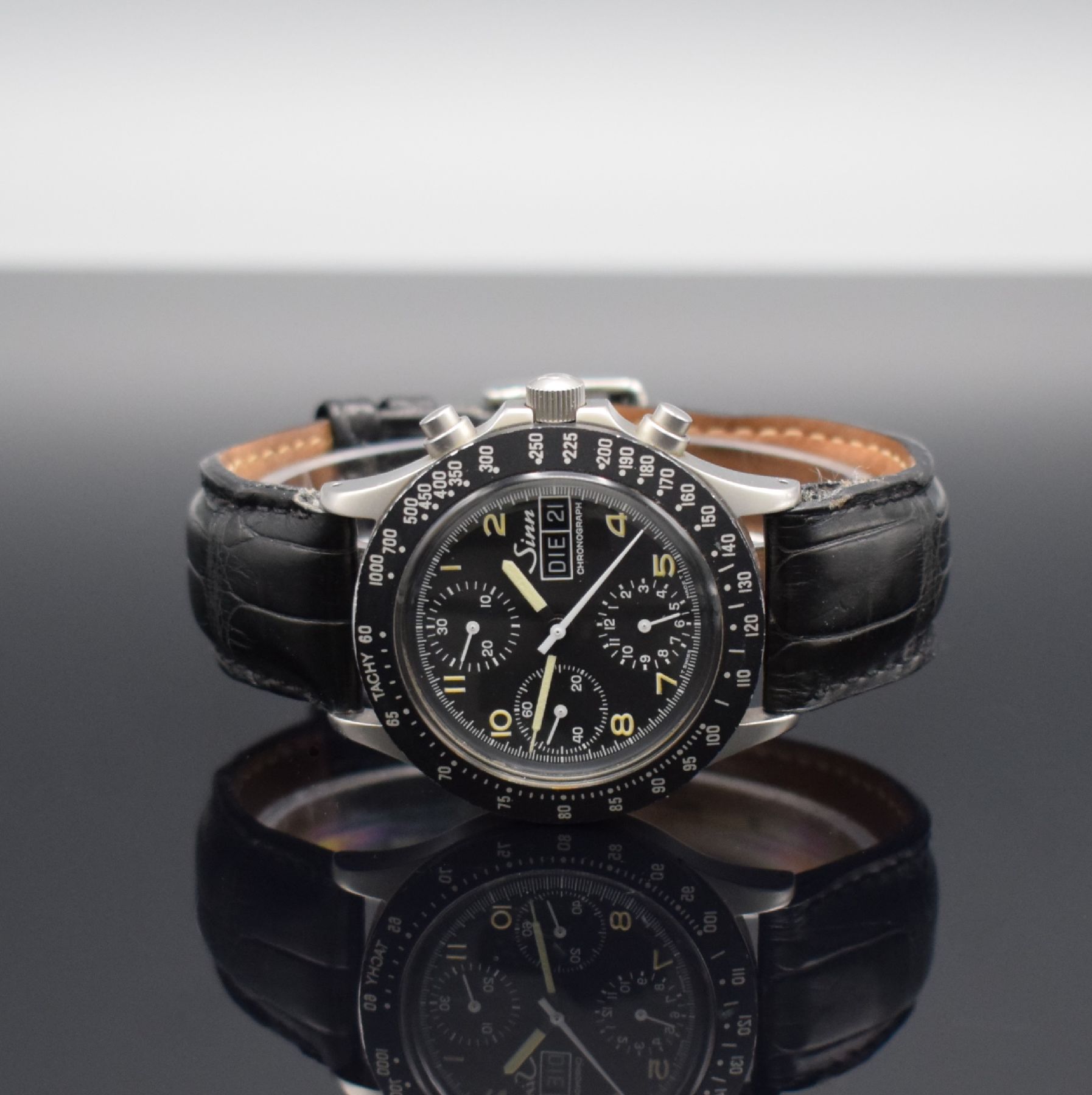 SINN Herrenarmbanduhr mit Chronograph, Schweiz um 1990, Automatik, verschr. Edelstahlgeh., Tachymeterskala, schwarzes Tritium-Zifferbl. m. arab. ...