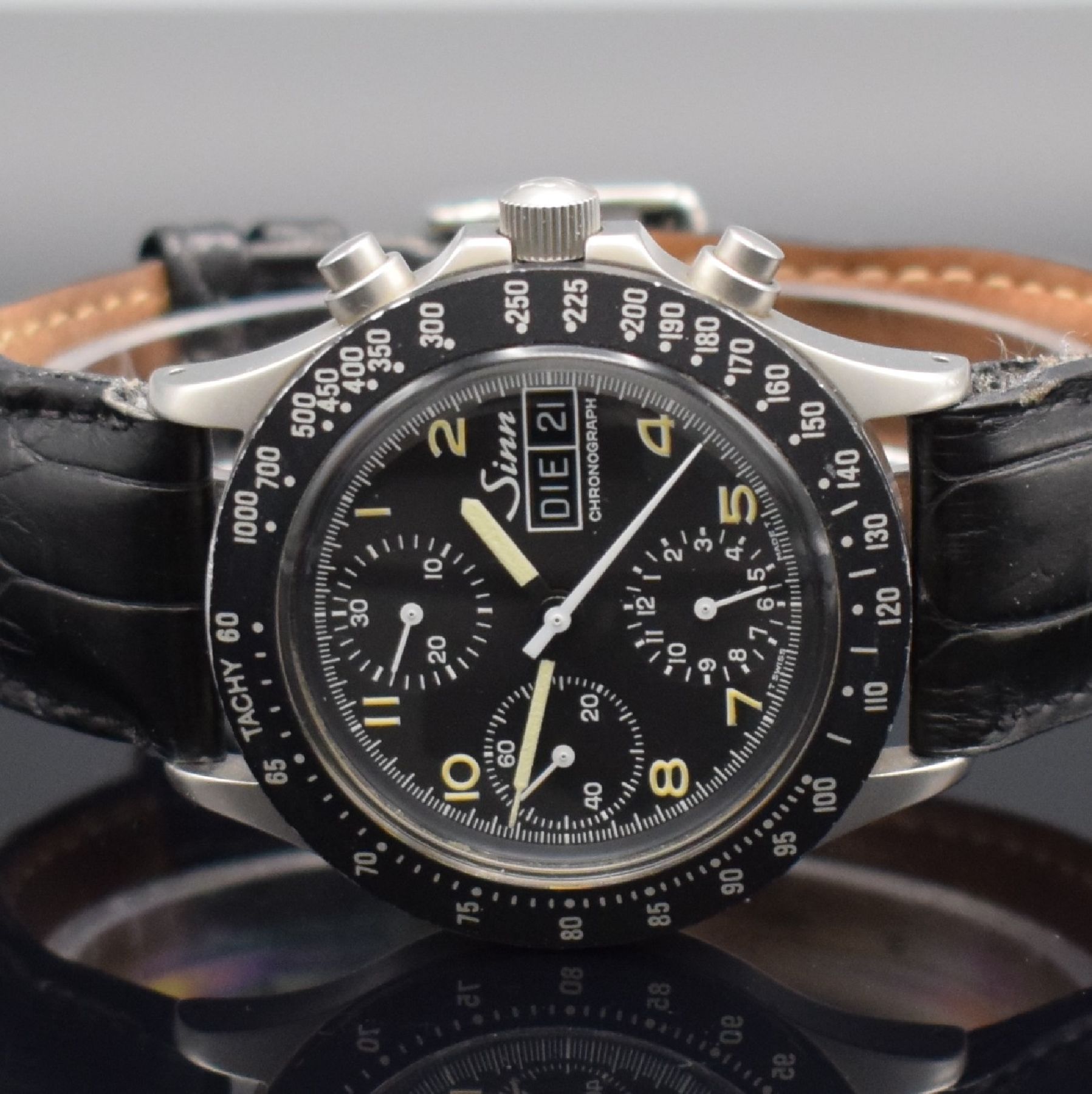 Detail a: SINN Herrenarmbanduhr mit Chronograph, Schweiz um 1990, Automatik, verschr. Edelstahlgeh., Tachymeterskala, schwarzes Tritium-Zifferbl. m. arab. ...