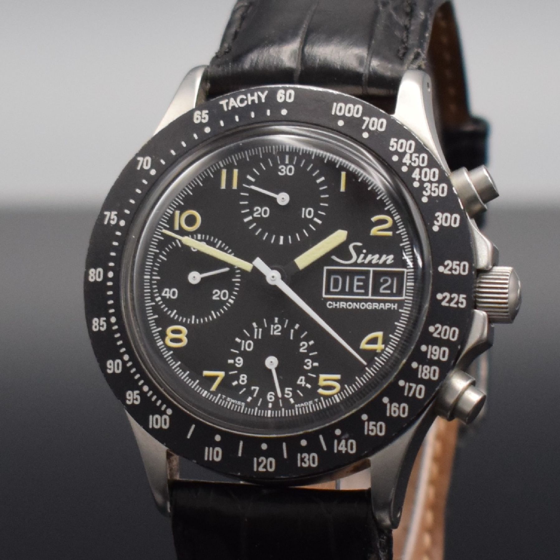 Detail c: SINN Herrenarmbanduhr mit Chronograph, Schweiz um 1990, Automatik, verschr. Edelstahlgeh., Tachymeterskala, schwarzes Tritium-Zifferbl. m. arab. ...