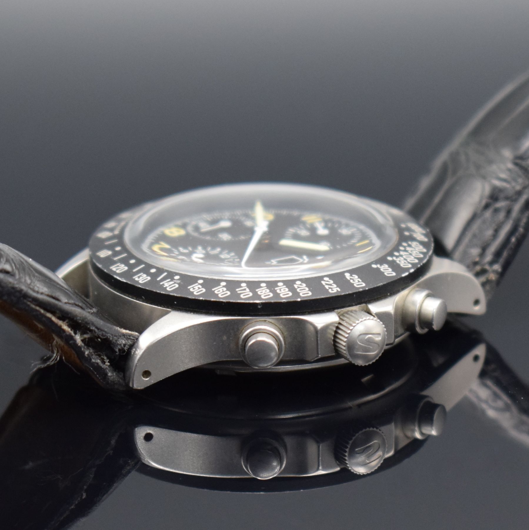 Detail d: SINN Herrenarmbanduhr mit Chronograph, Schweiz um 1990, Automatik, verschr. Edelstahlgeh., Tachymeterskala, schwarzes Tritium-Zifferbl. m. arab. ...