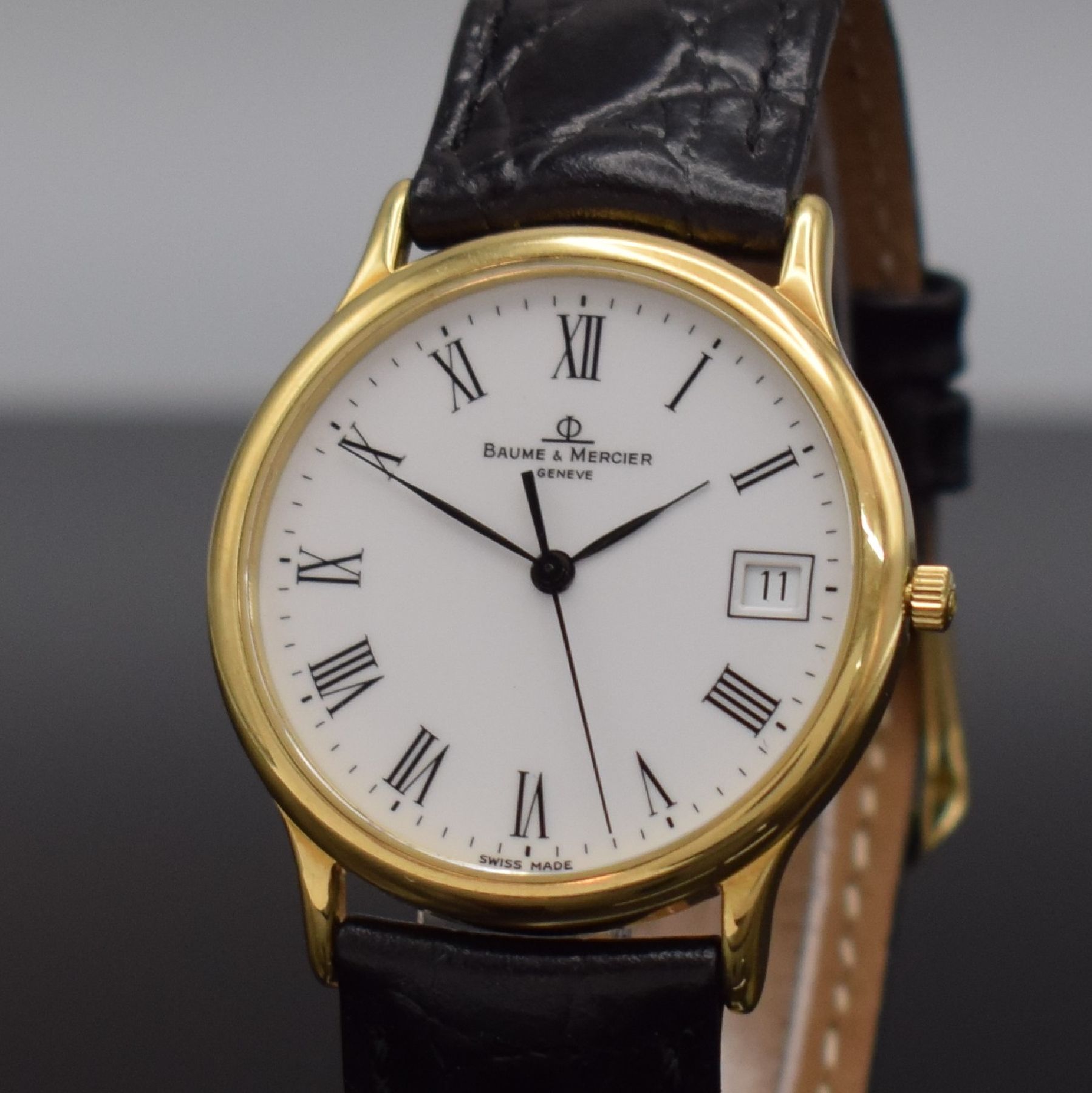 Detail c: BAUME & MERCIER Armbanduhr in GG 750/000, Schweiz um 1995, quarz, 2-teil. Geh., Boden aufgedr., weißes Zifferbl. m. röm. Zahlen, schwarze Zeiger, ...