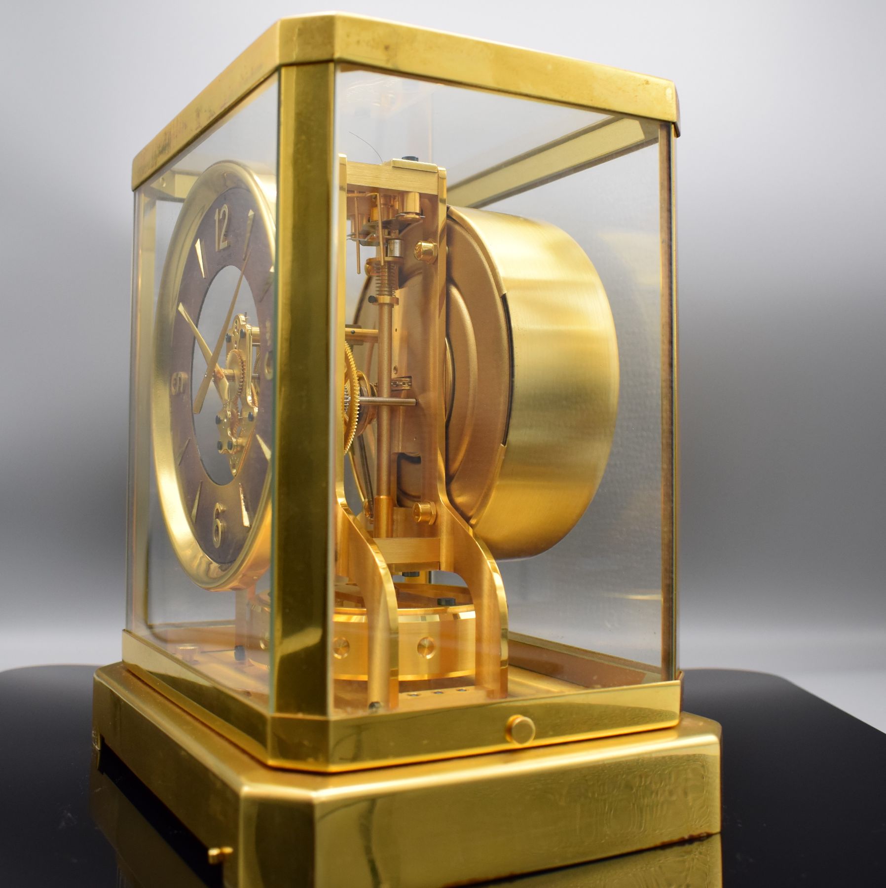 Detail e: LeCoultre Atmos III vergoldete Pendule Perpetuelle, Schweiz um 1960, 5-seitig verglastes Geh., Glasdom abnehmbar, Sicherungshebel im Sockel, vers. ...