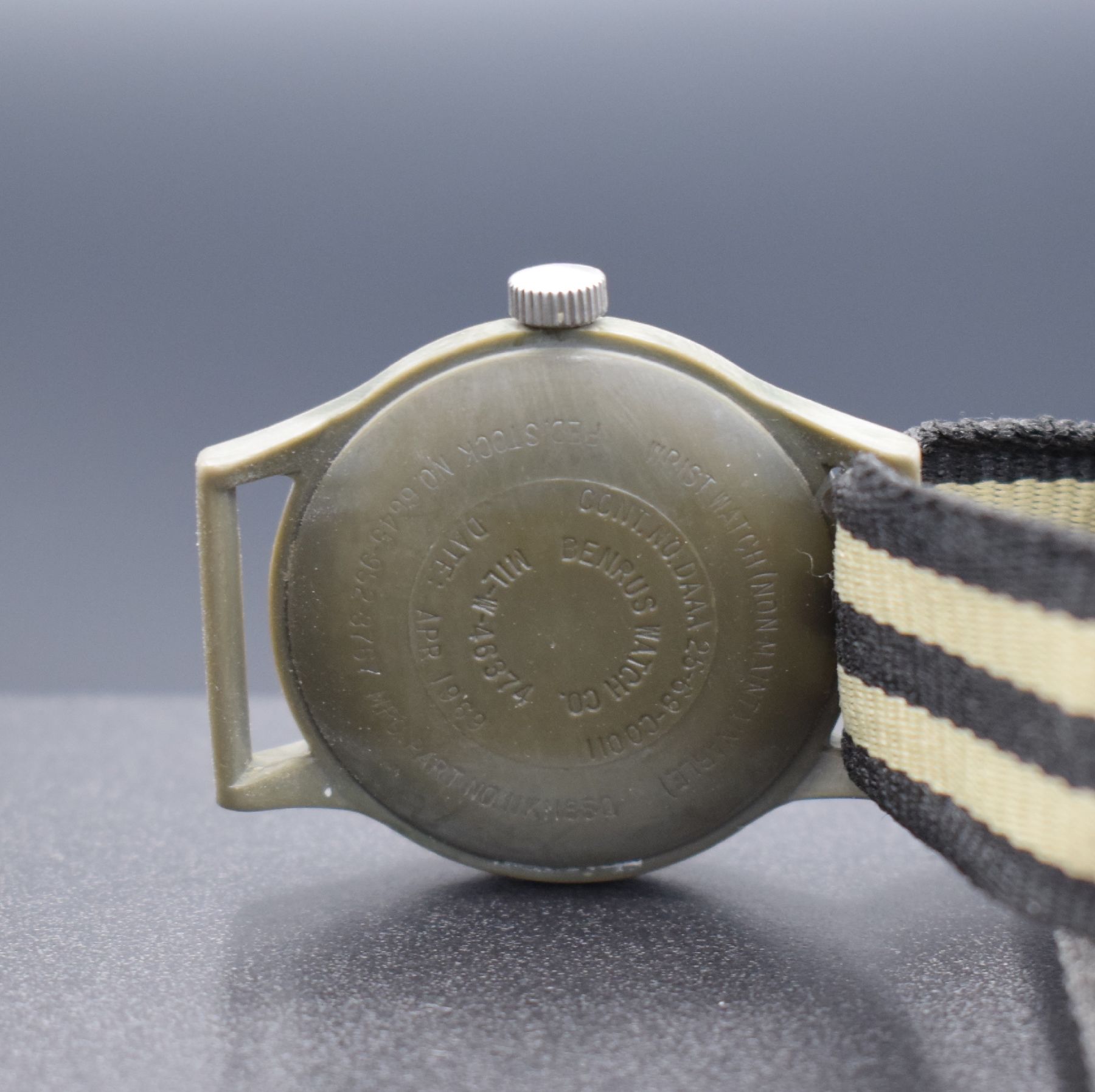 Detail d: BENRUS Militär-Armbanduhr der USA, USA / Schweiz 1969, einschaliges Kunststoffgeh. Versorgungsnummer 6645-952-3767, schwarzes Zifferbl., weiße ...