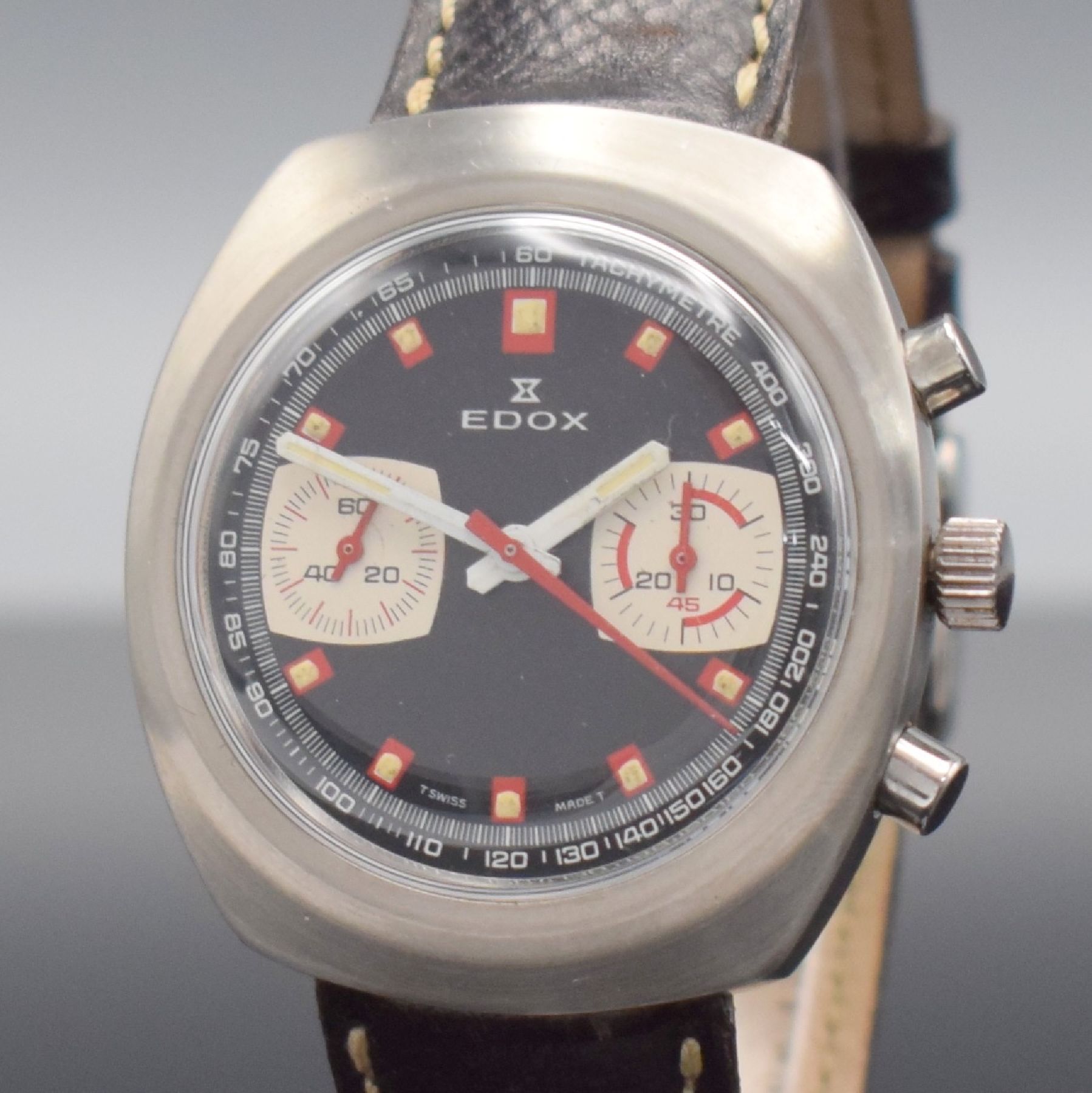 Detail a: EDOX Armbandchronograph in Stahl, Schweiz um 1970, Handaufzug, verschr. Geh., schwarzes Zifferbl., rote Leucht-Indizes, silb. Hilfsblätter, orig. ...