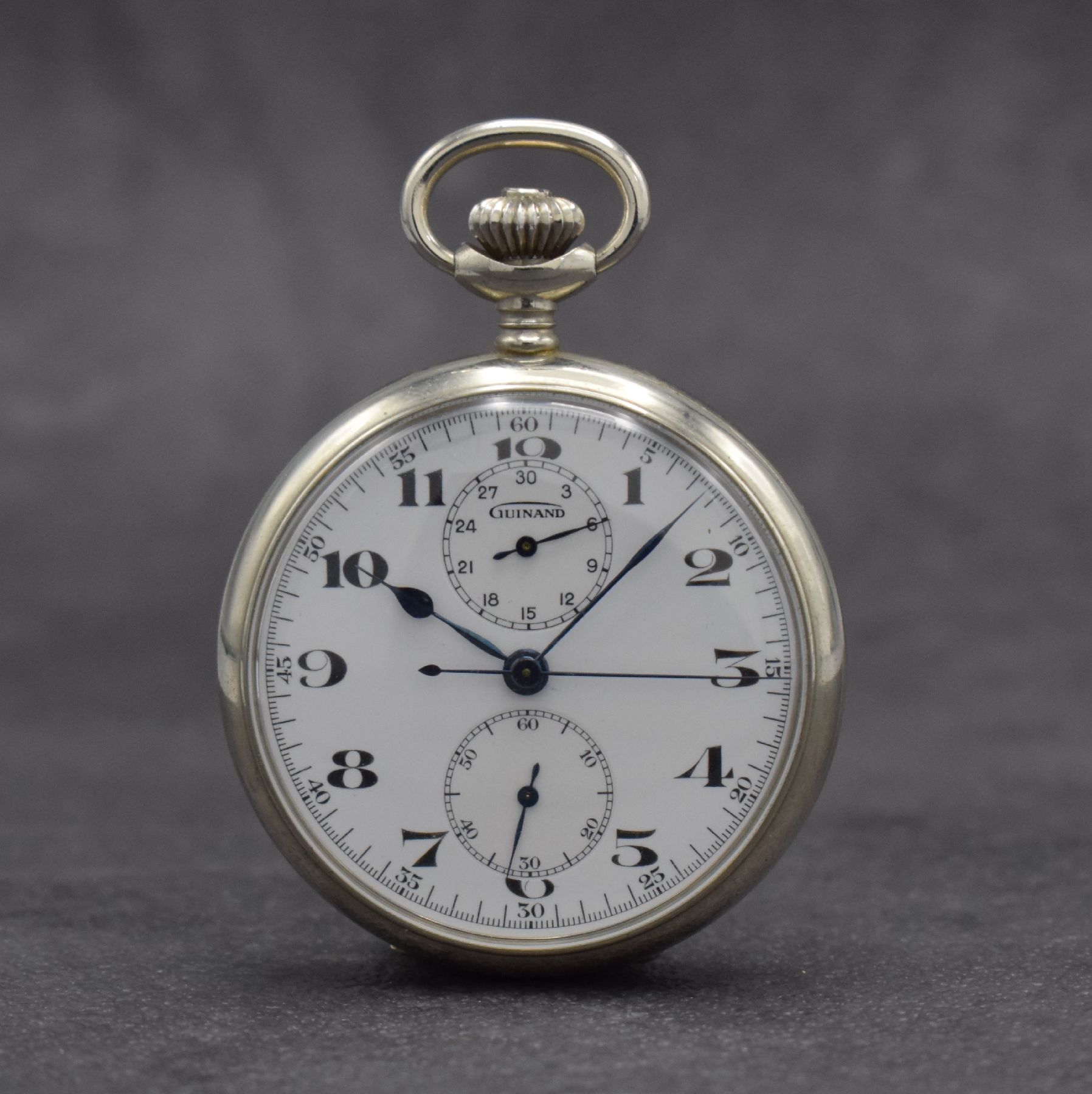 GUINAND offene Taschenuhr mit Chronograph, Schweiz um 1920, Nickel-Gehäuse, Rückseite mit Monogramm, Emailzifferbl. m. arab. Zahlen, gebl. Zeiger, ...