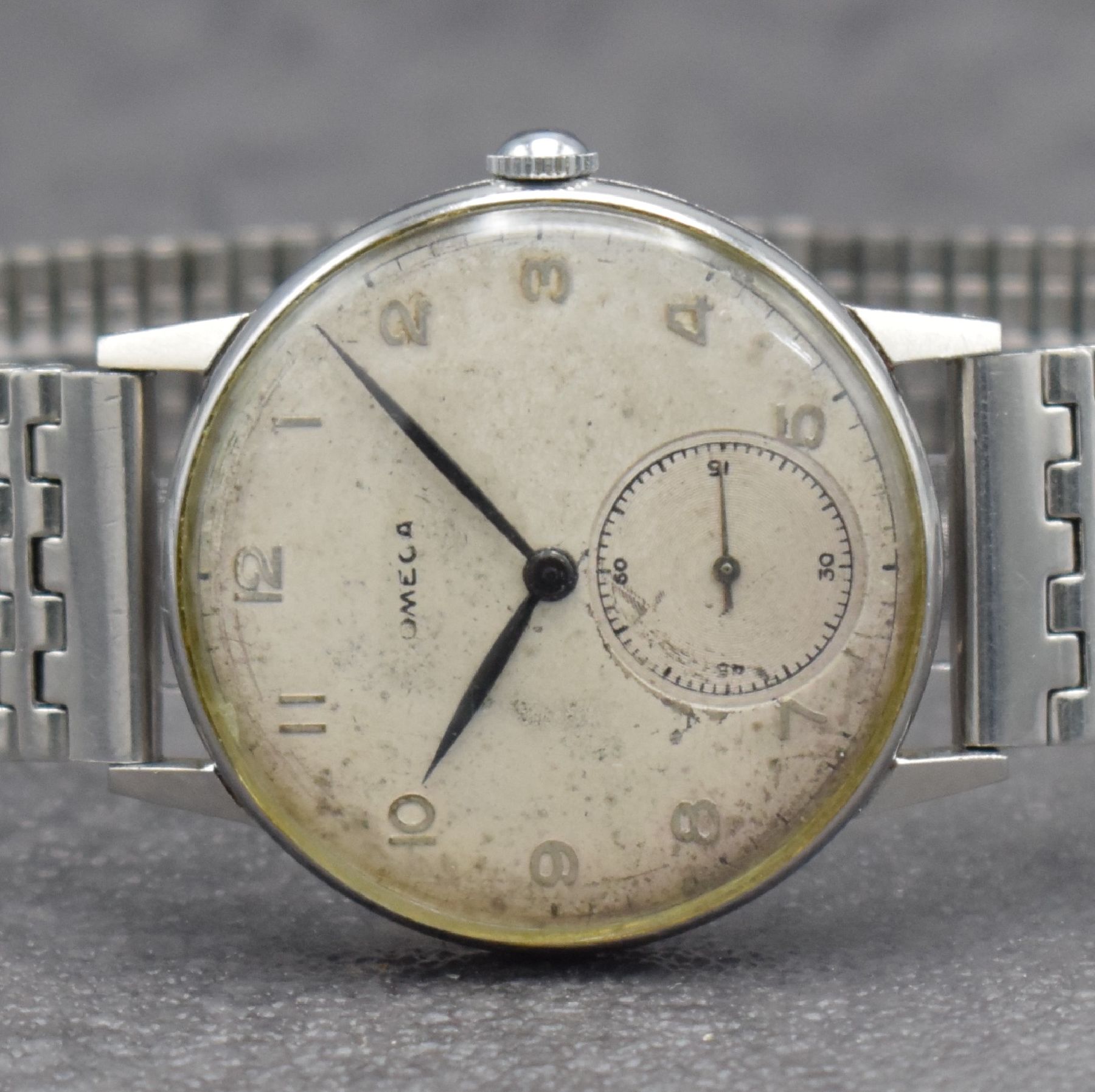 Detail a: OMEGA Herrenarmbanduhr in Stahl Ref. 2318/8, Schweiz um 1946, Handaufzug, 3-teil. Geh., Boden & Glasrand aufgedr., NSA-Stahlband, silb. Zifferbl. m. ...