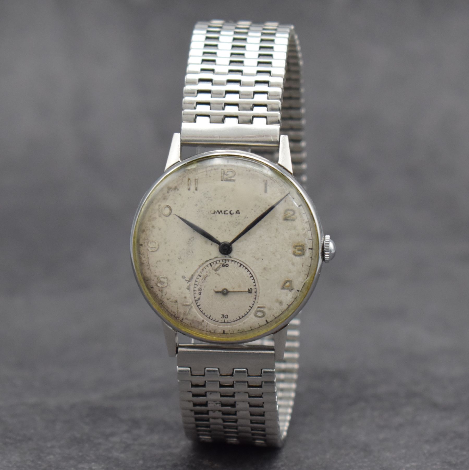Detail b: OMEGA Herrenarmbanduhr in Stahl Ref. 2318/8, Schweiz um 1946, Handaufzug, 3-teil. Geh., Boden & Glasrand aufgedr., NSA-Stahlband, silb. Zifferbl. m. ...