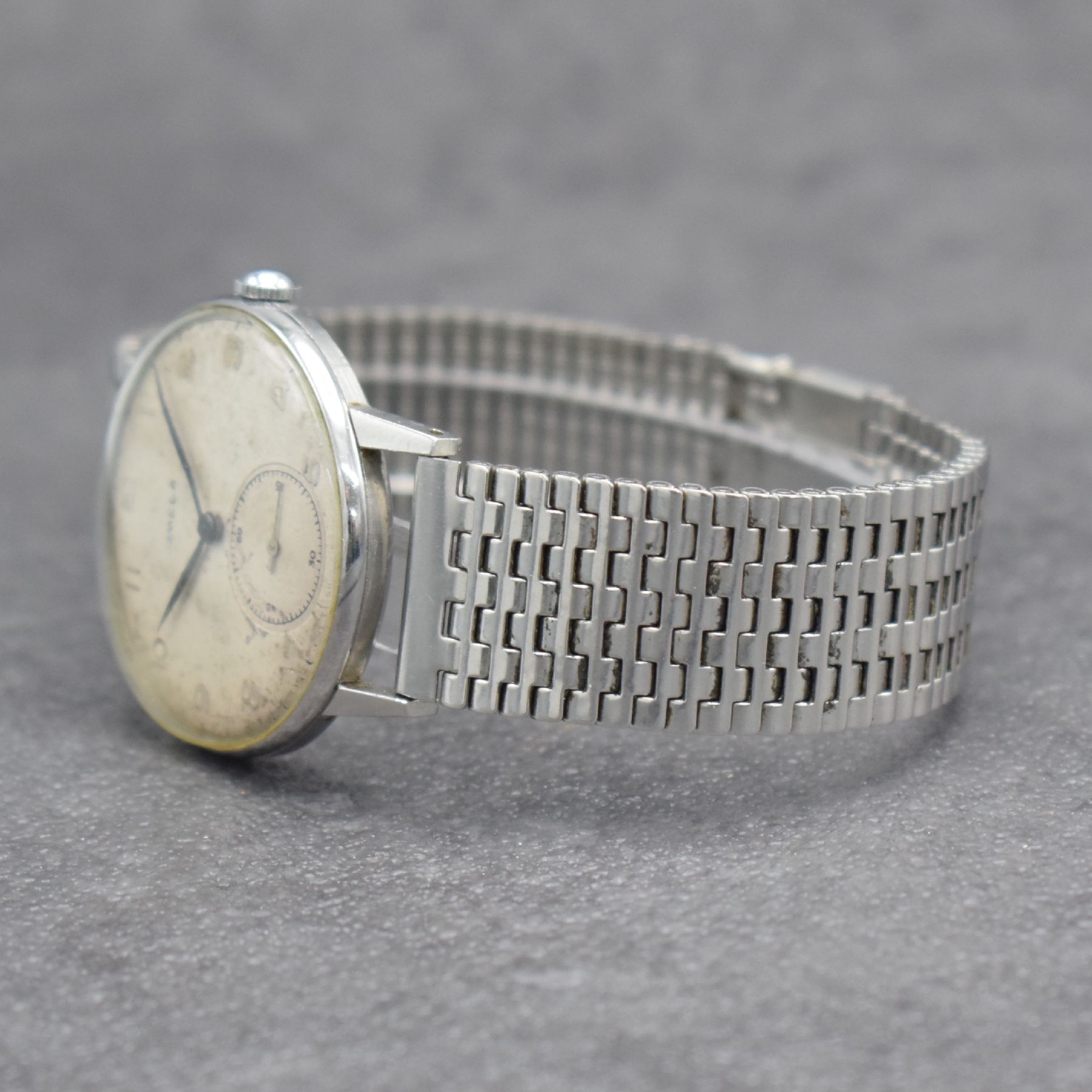 Detail d: OMEGA Herrenarmbanduhr in Stahl Ref. 2318/8, Schweiz um 1946, Handaufzug, 3-teil. Geh., Boden & Glasrand aufgedr., NSA-Stahlband, silb. Zifferbl. m. ...