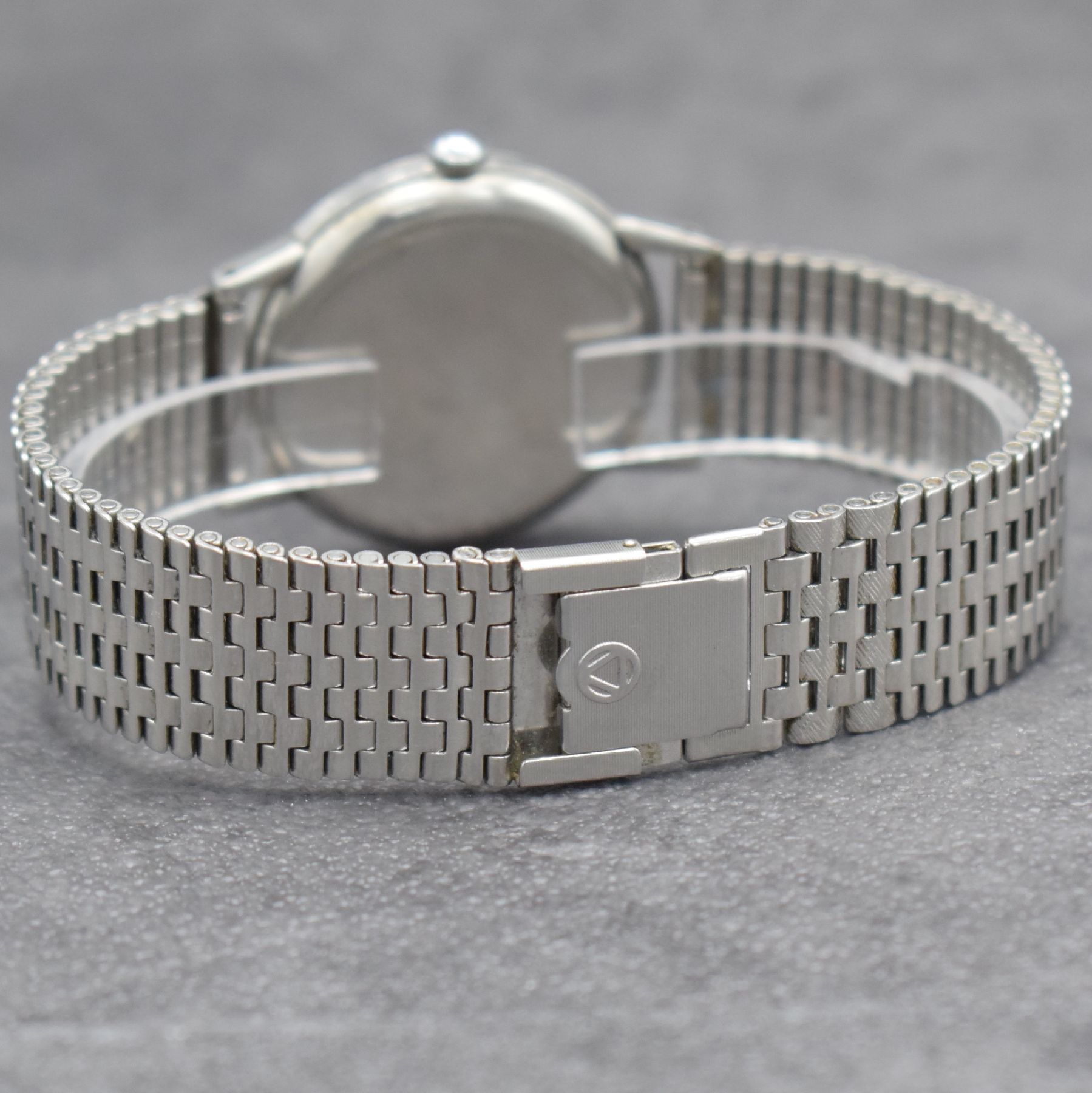 Detail e: OMEGA Herrenarmbanduhr in Stahl Ref. 2318/8, Schweiz um 1946, Handaufzug, 3-teil. Geh., Boden & Glasrand aufgedr., NSA-Stahlband, silb. Zifferbl. m. ...