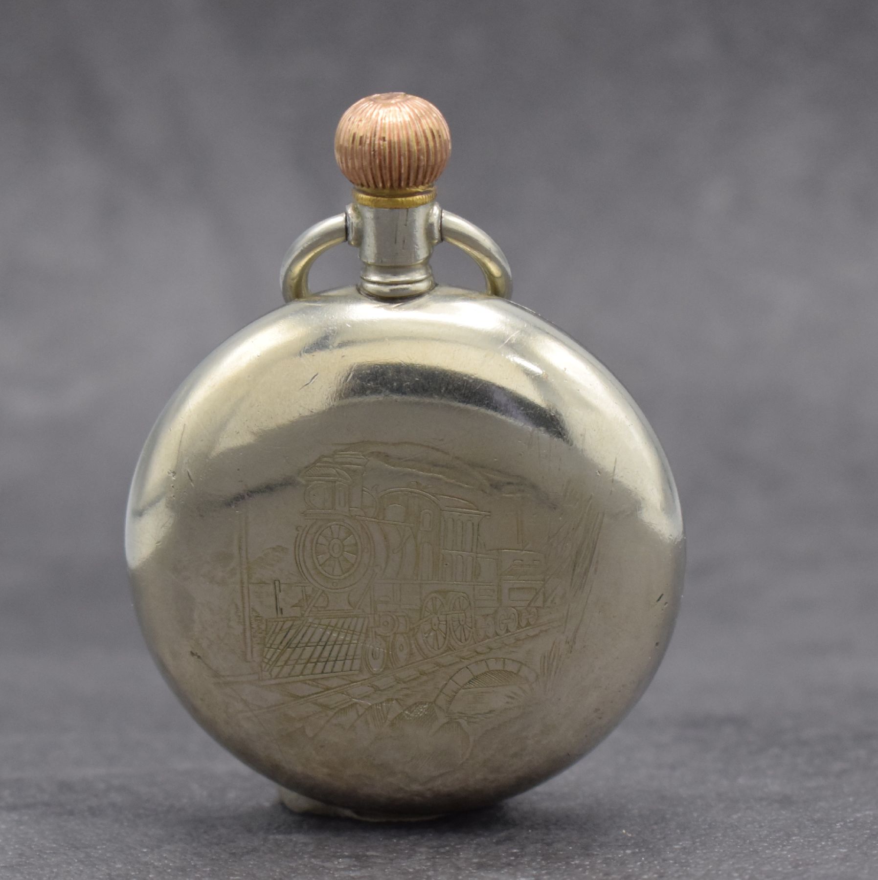 Detail a: OMEGA 2 offene Taschenuhren in Nickel, Schweiz, 1) um 1916, großes Gehäuse m. geschr. Lünette, rücks. Lok-Darstellung, Emailzifferbl. ...