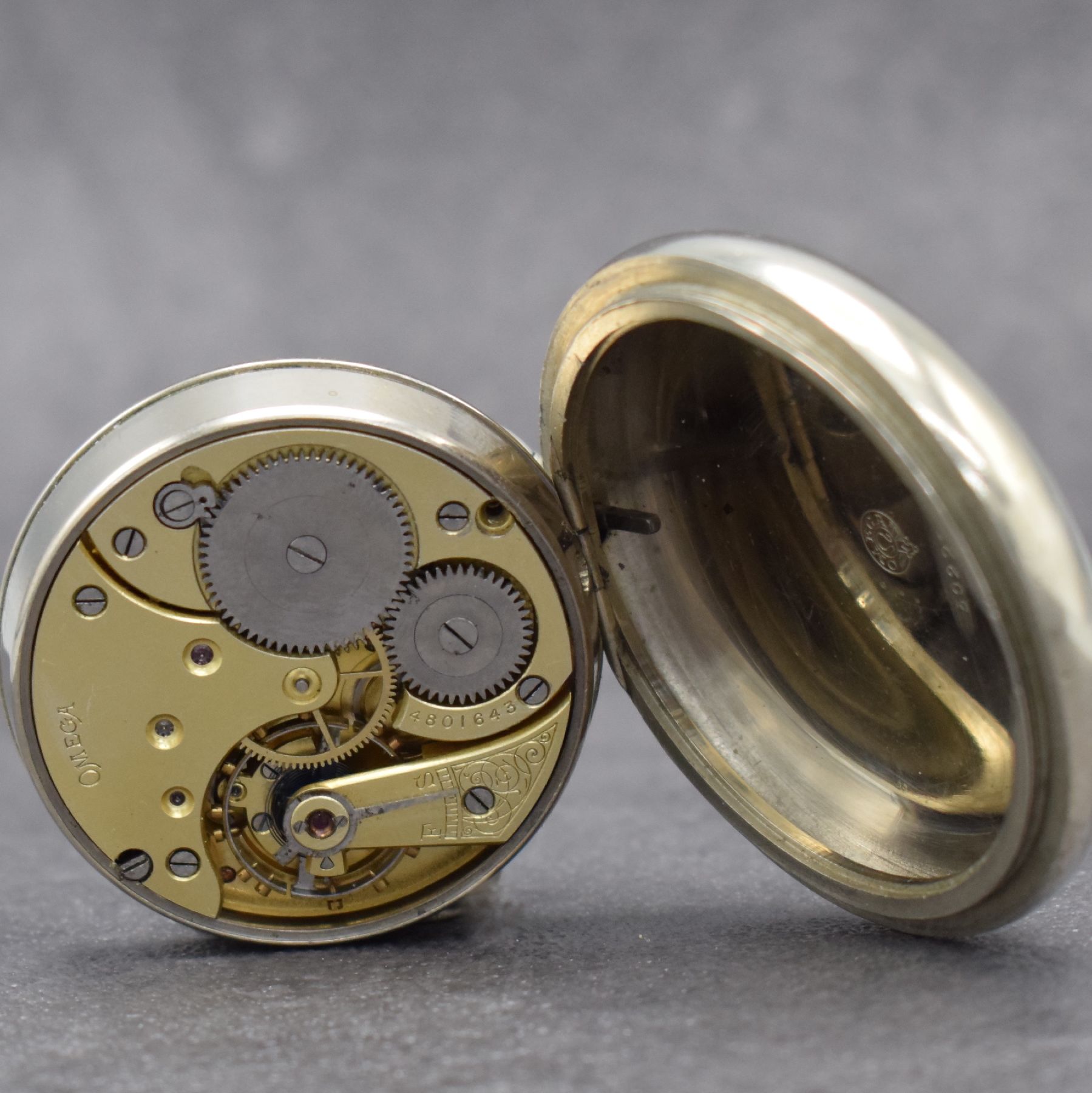 Detail b: OMEGA 2 offene Taschenuhren in Nickel, Schweiz, 1) um 1916, großes Gehäuse m. geschr. Lünette, rücks. Lok-Darstellung, Emailzifferbl. ...