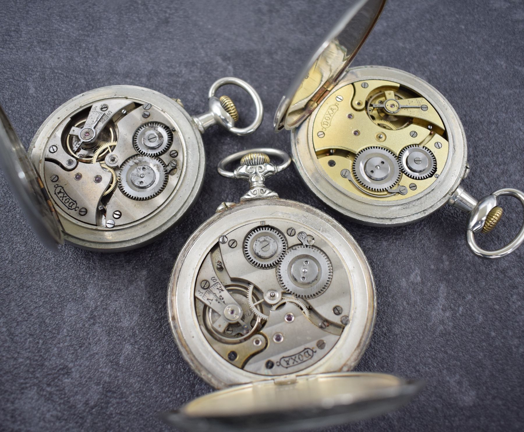 Detail b: 3 DOXA große offene Taschenuhren, Schweiz um 1900, Kronenaufzug, Nickelgehäuse, Emailzifferbl. teils besch. m. arab. Zahlen, Stahlzeiger, ...