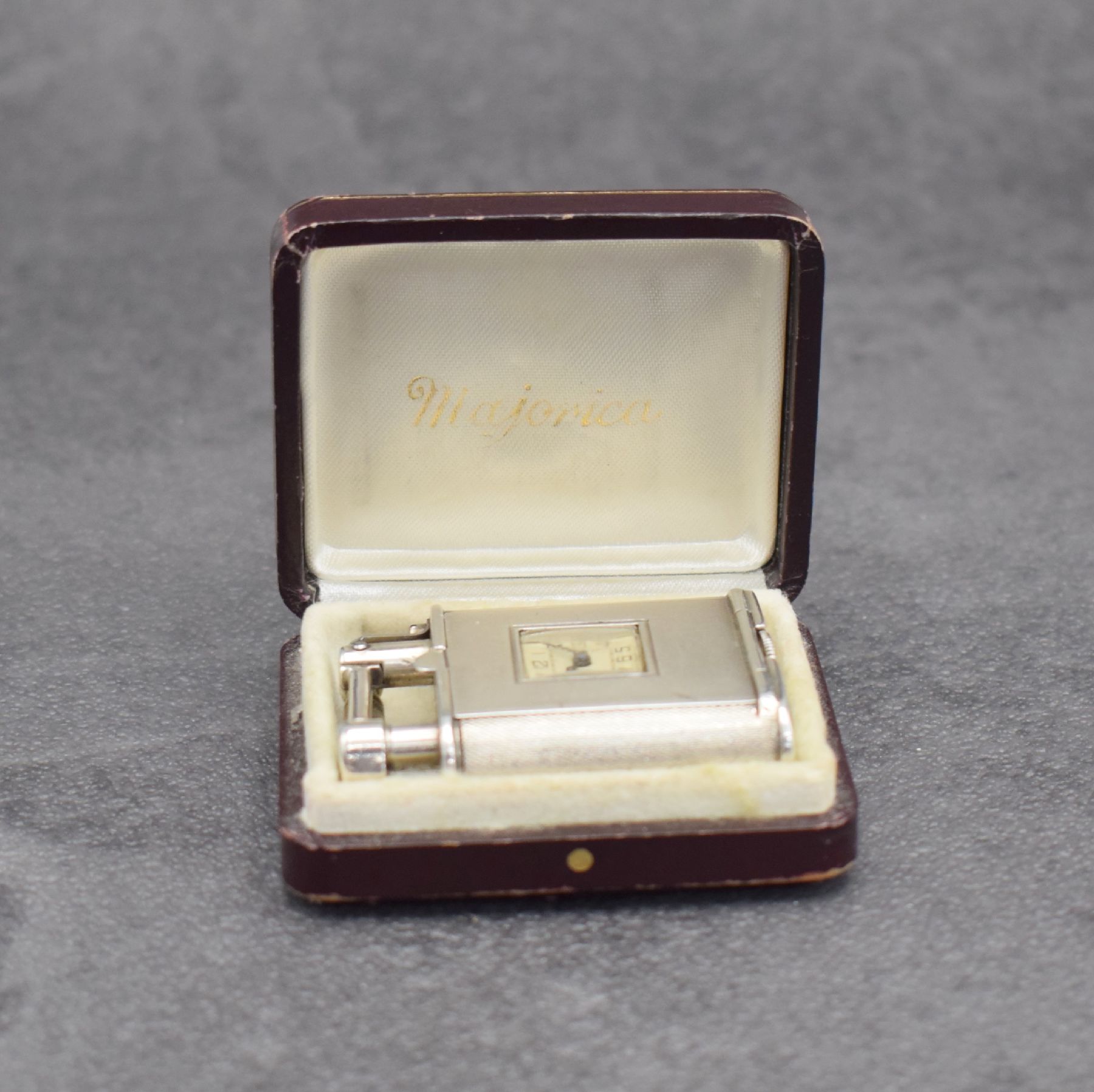 Detail h: Benzinfeuerzeug mit eingelassener Uhr in 900er Silber, Schweiz um 1930, rundum guill. Geh., Front mit Scharnier aufklappbar, Boden über verg. Werk ...
