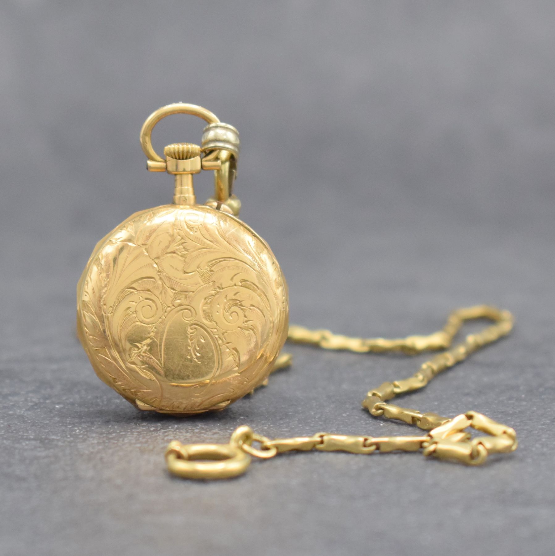 Detail b: Kleine Damentaschenuhr in GG 750/000 an GG 585/000 Kette, Schweiz um 1900, aufw. grav. Geh., Goldcuv., Emailzifferbl. m. röm. Std. & arab. ...