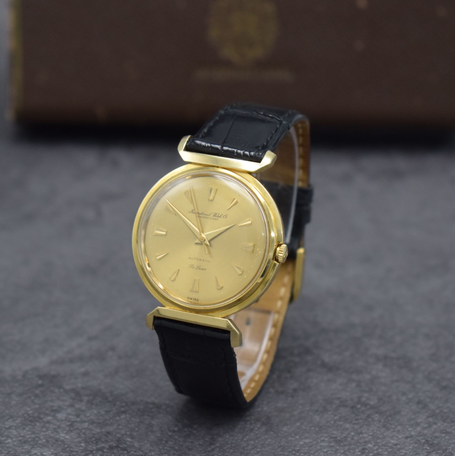 Detail b: IWC Herrenarmbanduhr De Luxe in GG 750/000, Automatik, Schweiz um 1957, Boden aufgedr., gold. Zifferbl. m. aufges. Gold-Std.-Indizes, Gold-Zeiger, ...