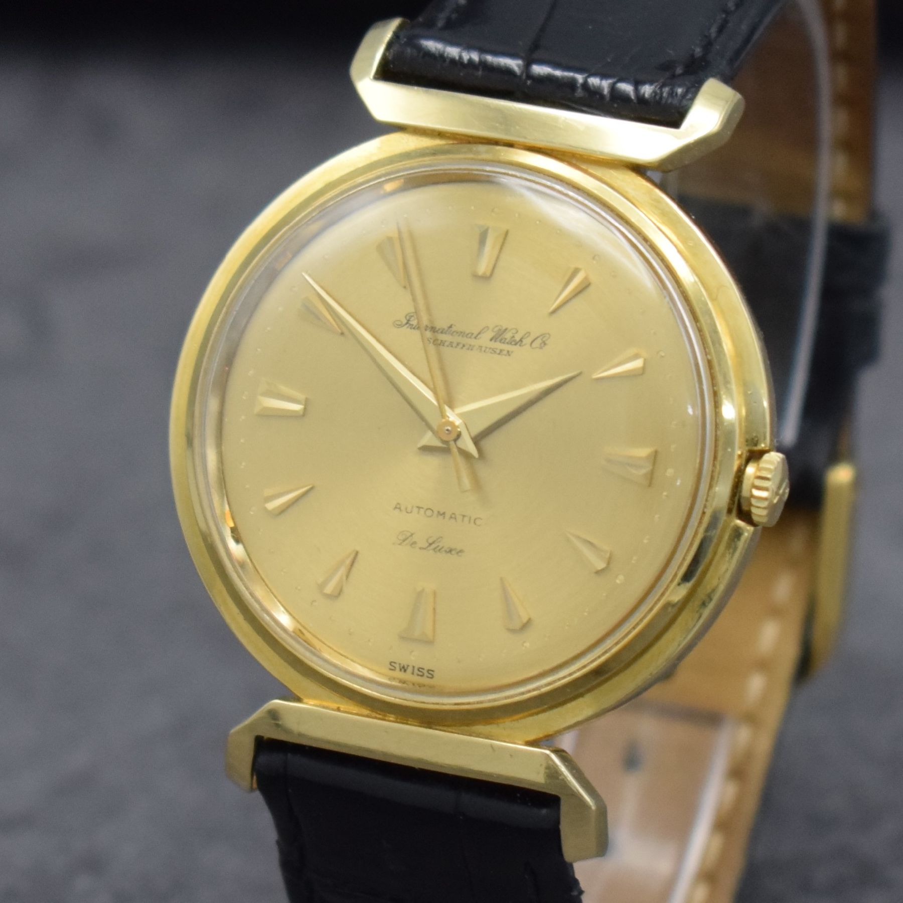 Detail c: IWC Herrenarmbanduhr De Luxe in GG 750/000, Automatik, Schweiz um 1957, Boden aufgedr., gold. Zifferbl. m. aufges. Gold-Std.-Indizes, Gold-Zeiger, ...