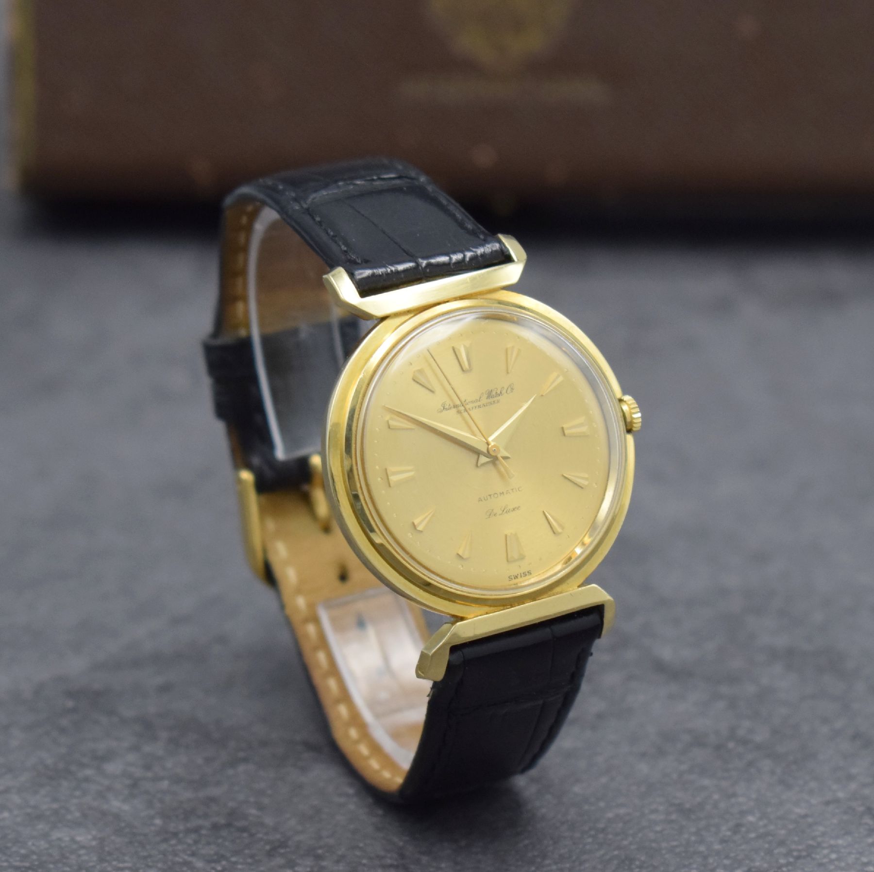 Detail d: IWC Herrenarmbanduhr De Luxe in GG 750/000, Automatik, Schweiz um 1957, Boden aufgedr., gold. Zifferbl. m. aufges. Gold-Std.-Indizes, Gold-Zeiger, ...