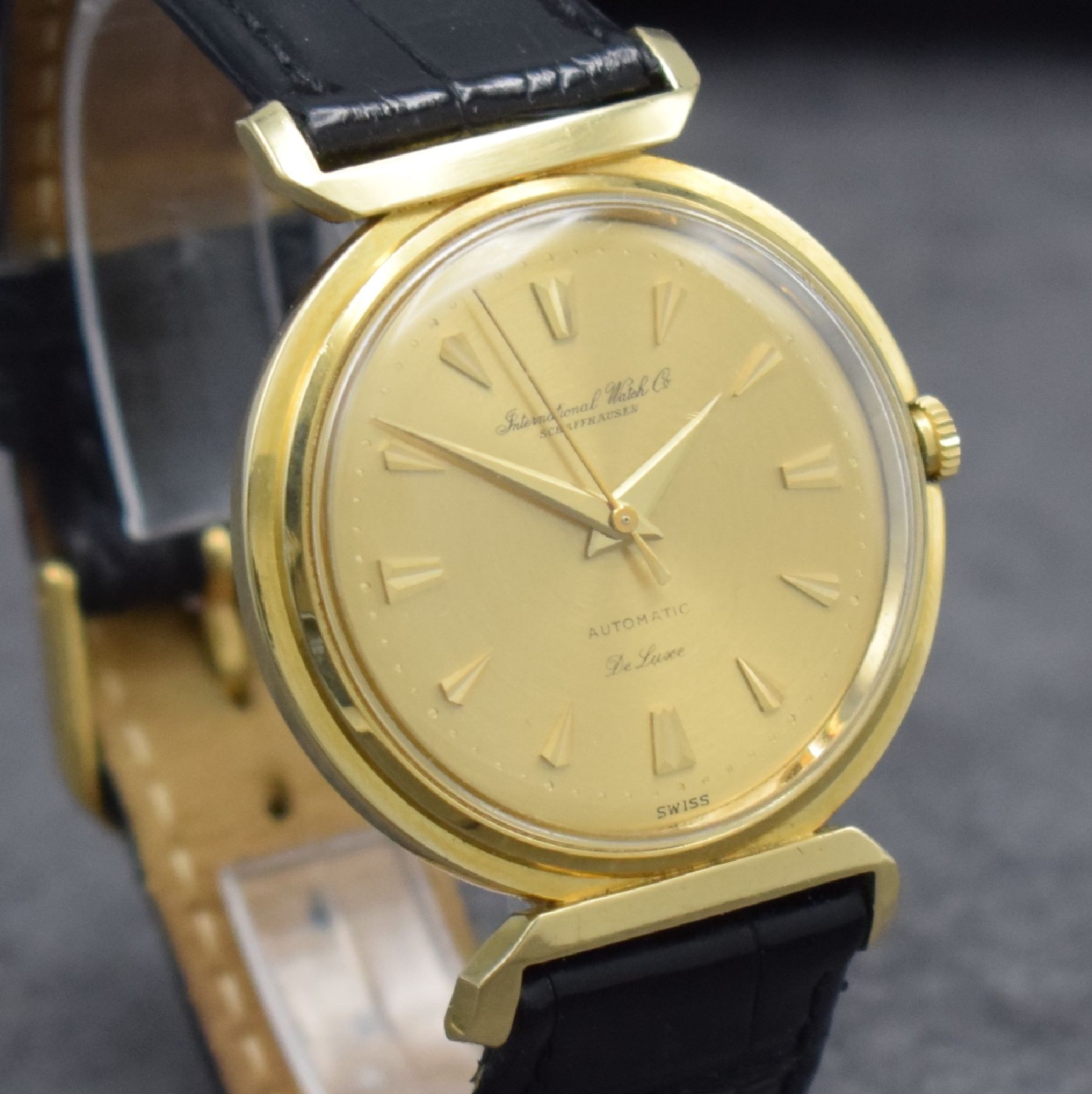 Detail e: IWC Herrenarmbanduhr De Luxe in GG 750/000, Automatik, Schweiz um 1957, Boden aufgedr., gold. Zifferbl. m. aufges. Gold-Std.-Indizes, Gold-Zeiger, ...