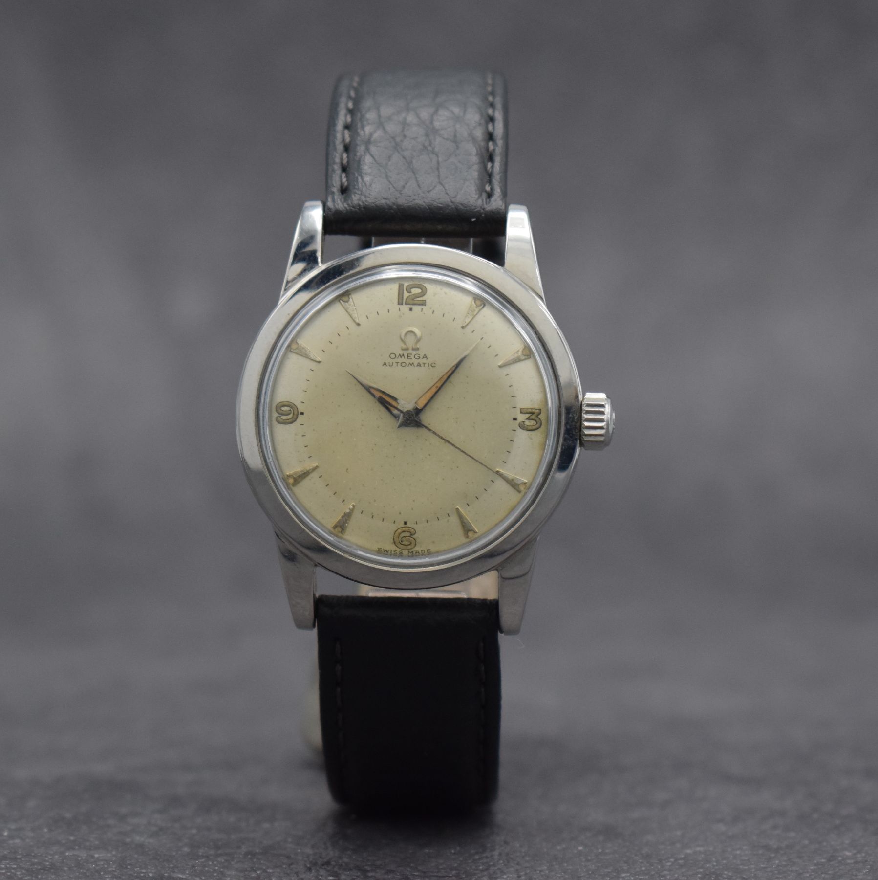 Detail b: OMEGA Herrenarmbanduhr mit Hammerautomatik Ref. 2577-1, Schweiz um 1950, Edelstahlgeh. m. geschr. Boden, silb. Zifferbl. m. aufges. Std.-Ind. fl., ...