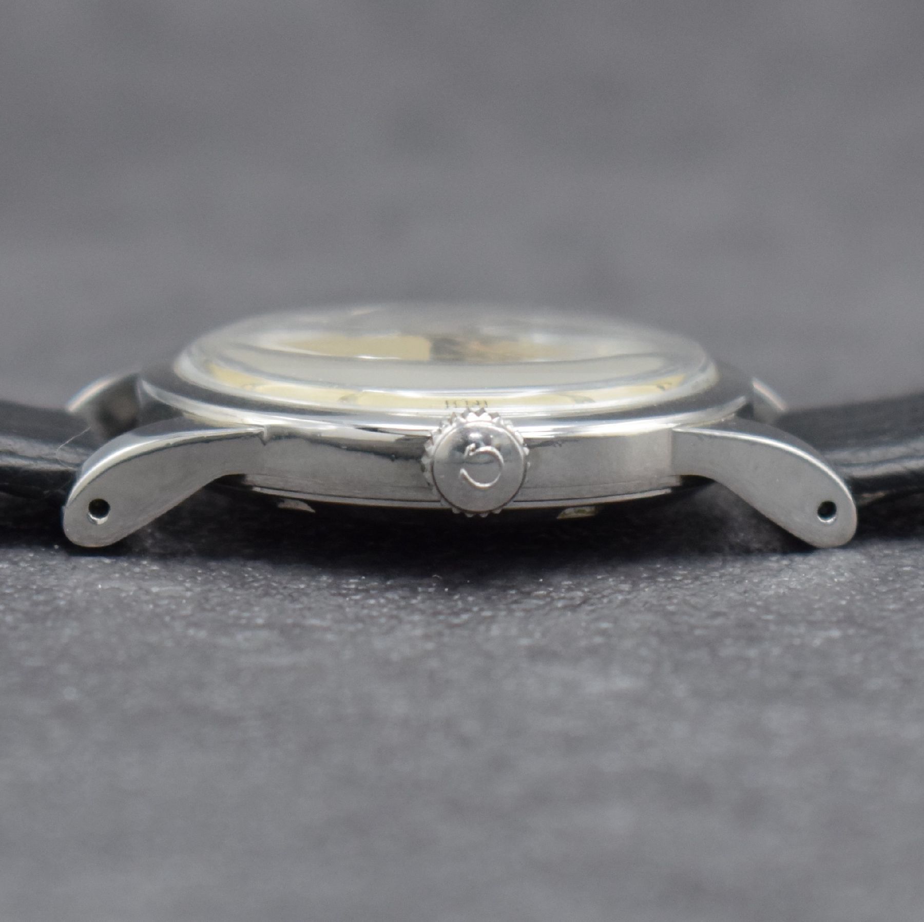 Detail d: OMEGA Herrenarmbanduhr mit Hammerautomatik Ref. 2577-1, Schweiz um 1950, Edelstahlgeh. m. geschr. Boden, silb. Zifferbl. m. aufges. Std.-Ind. fl., ...