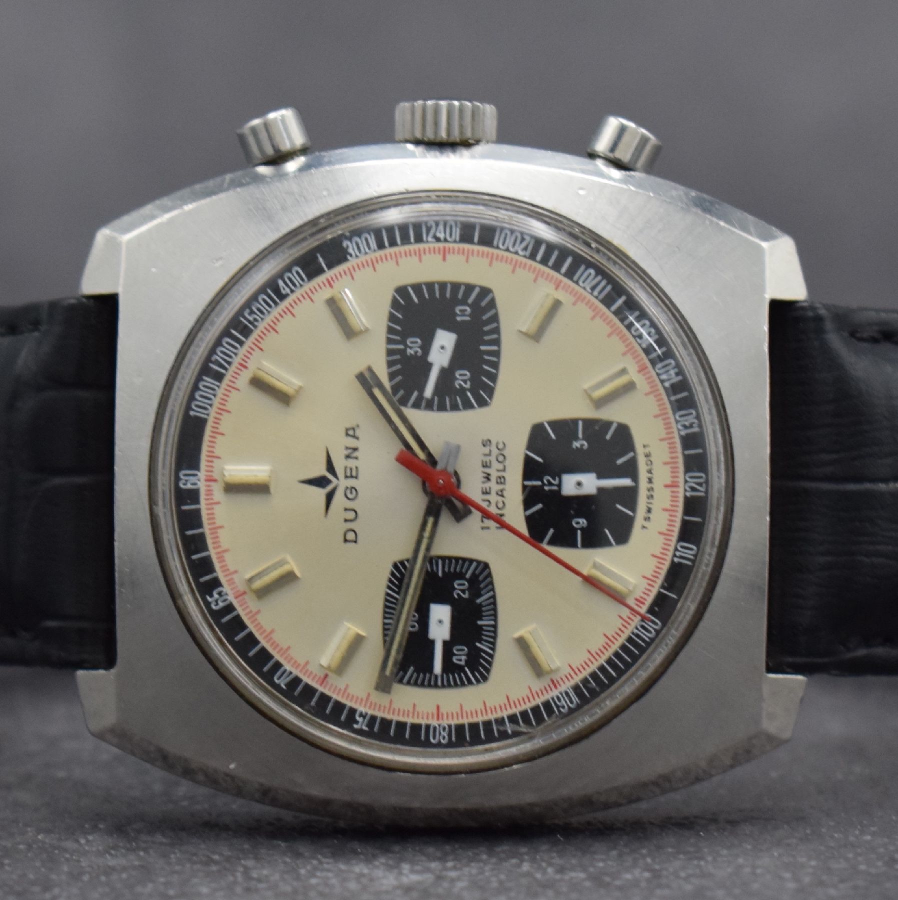 Detail a: DUGENA Herrenarmbanduhr mit Chronograph, Schweiz um 1970, Handaufzug, massives Edelstahlgeh. m. geschr. Boden, silb. Zifferbl. m. aufges. Std.-Ind., ...