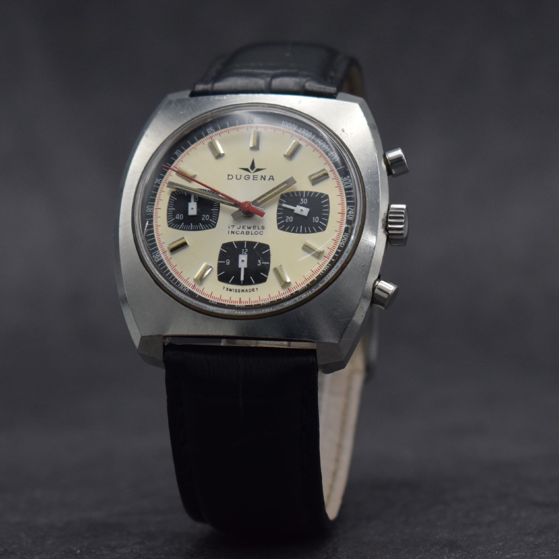 Detail b: DUGENA Herrenarmbanduhr mit Chronograph, Schweiz um 1970, Handaufzug, massives Edelstahlgeh. m. geschr. Boden, silb. Zifferbl. m. aufges. Std.-Ind., ...
