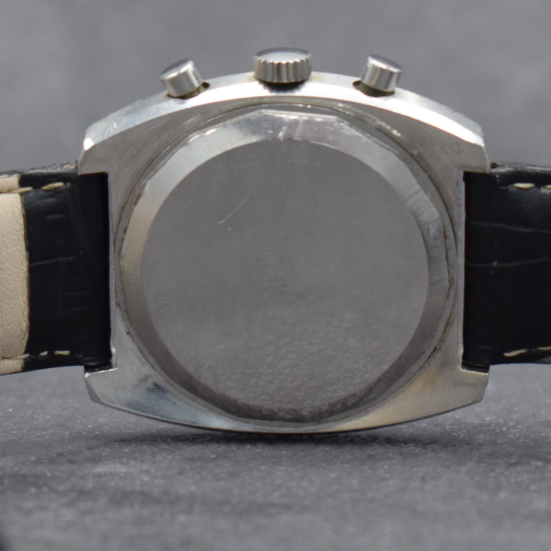 Detail e: DUGENA Herrenarmbanduhr mit Chronograph, Schweiz um 1970, Handaufzug, massives Edelstahlgeh. m. geschr. Boden, silb. Zifferbl. m. aufges. Std.-Ind., ...