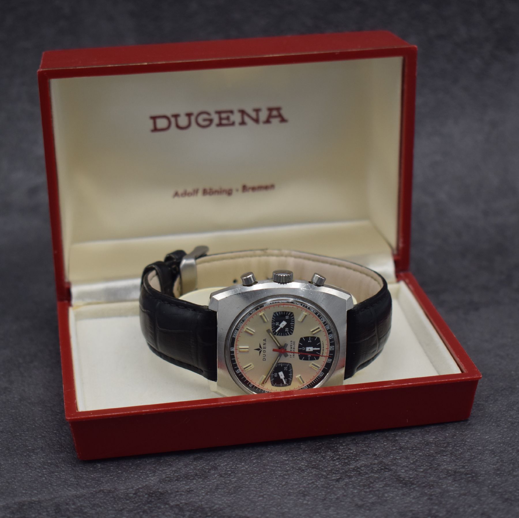 Detail h: DUGENA Herrenarmbanduhr mit Chronograph, Schweiz um 1970, Handaufzug, massives Edelstahlgeh. m. geschr. Boden, silb. Zifferbl. m. aufges. Std.-Ind., ...