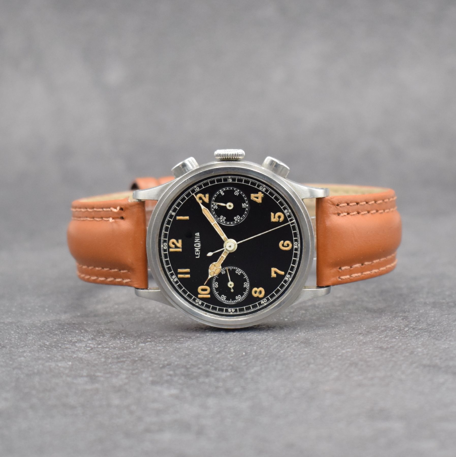 LEMANIA Schaltradchronograph, Handaufzug, Schweiz 1940er Jahre, Edelstahlgeh., Boden & Glasrand aufgedr., schwarzes Zifferbl. m. fetten, arab. ...