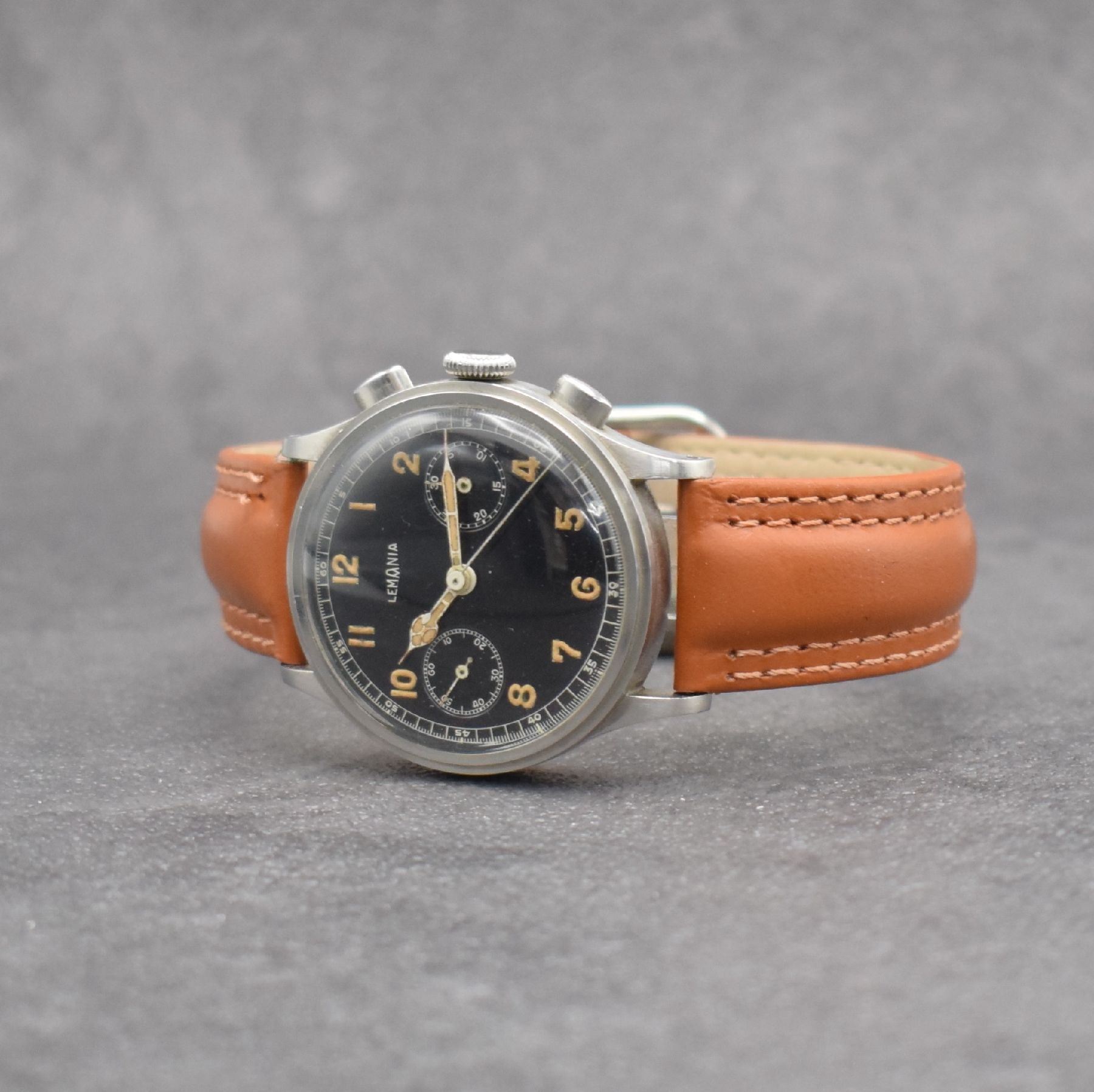 Detail b: LEMANIA Schaltradchronograph, Handaufzug, Schweiz 1940er Jahre, Edelstahlgeh., Boden & Glasrand aufgedr., schwarzes Zifferbl. m. fetten, arab. ...