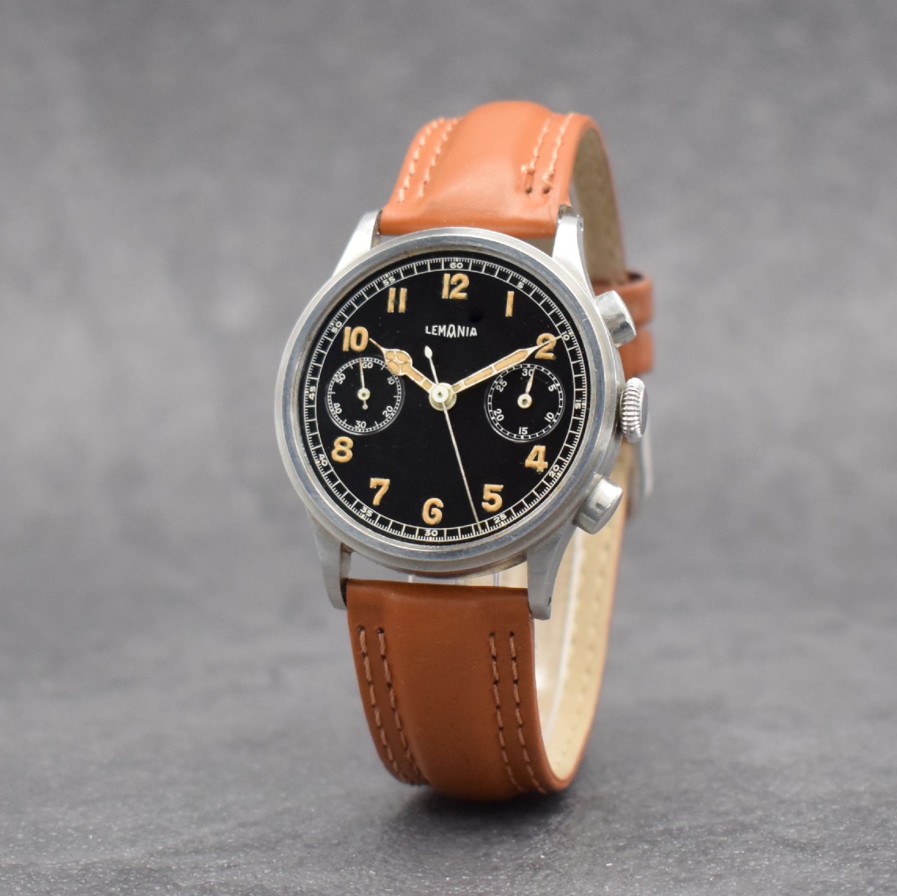 Detail c: LEMANIA Schaltradchronograph, Handaufzug, Schweiz 1940er Jahre, Edelstahlgeh., Boden & Glasrand aufgedr., schwarzes Zifferbl. m. fetten, arab. ...